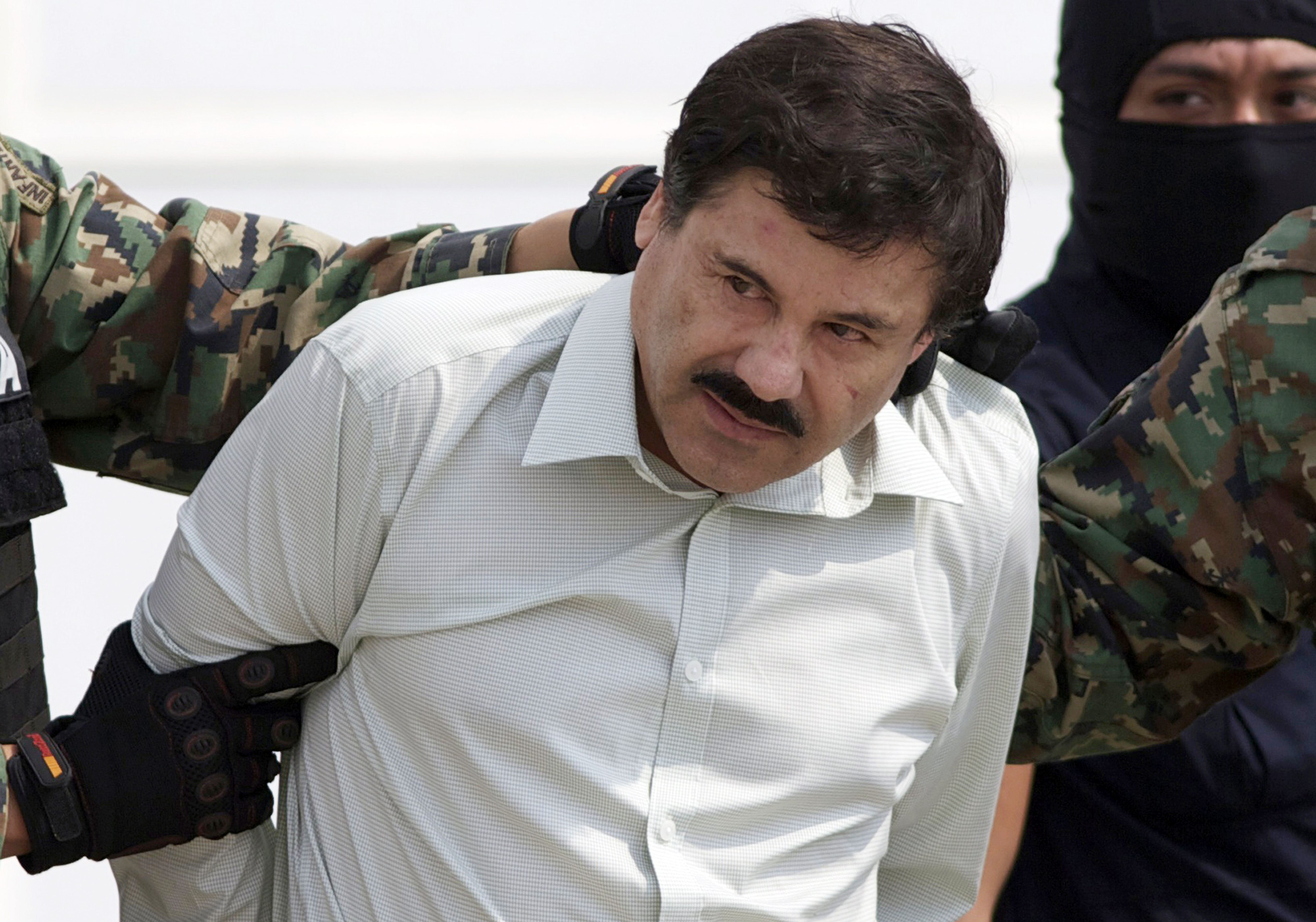 Joaquin "El Chapo" Guzman, the head of Mexico's Sinaloa Cartel, being escorted to a helicopter in Mexico City following his capture in the beach resort town of Mazatlan