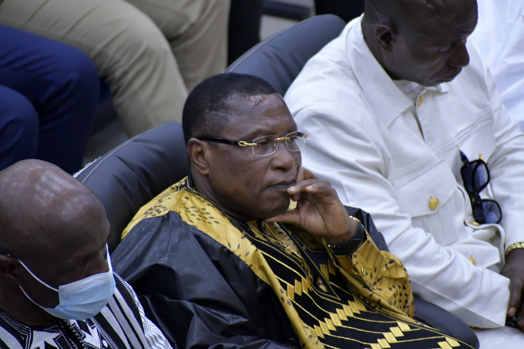 Former junta leader Moussa “Dadis” Camara, left, listens during a court verdict in Conakry, Guinea