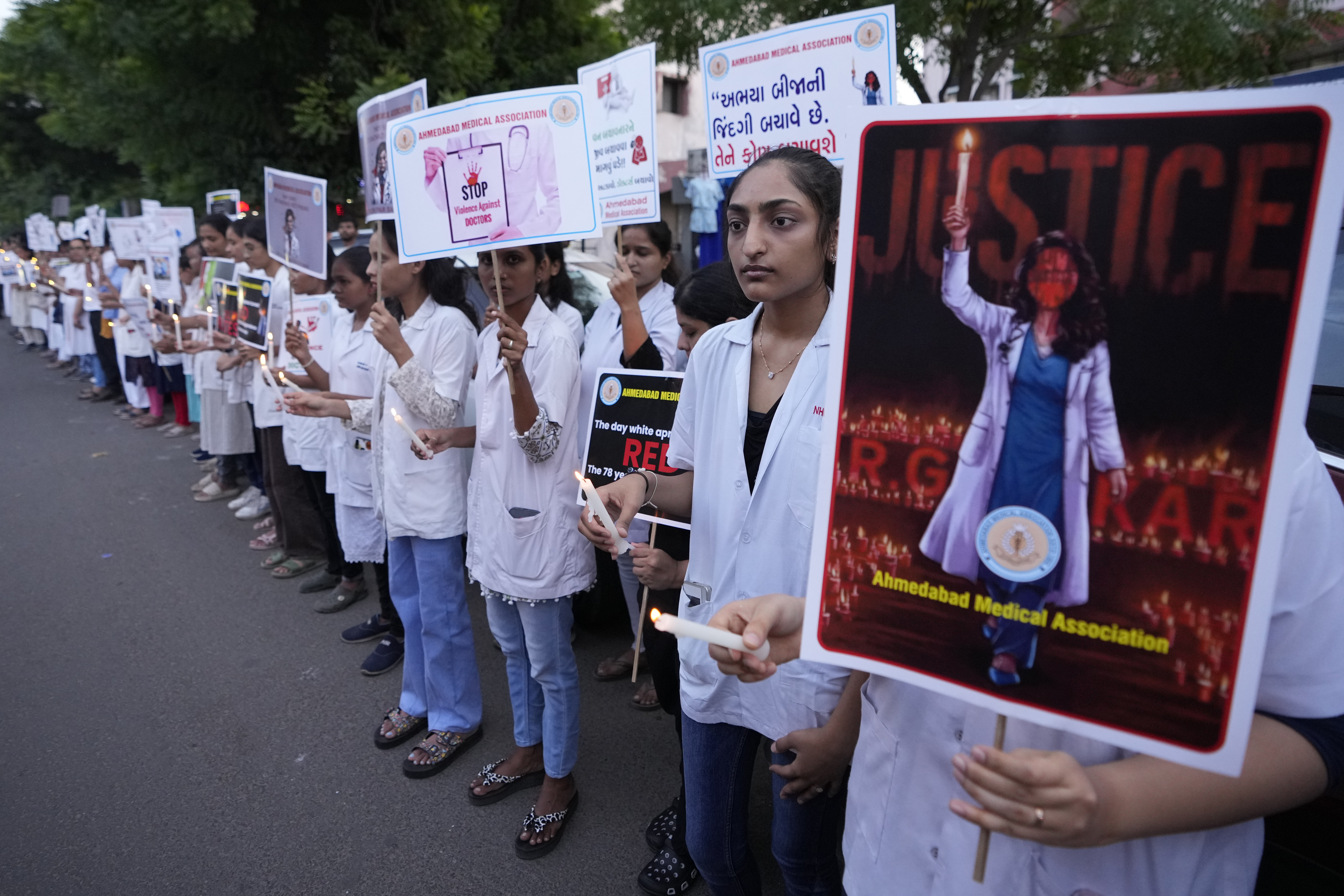 Doctors and medical students hold placards and candles during a protest against the rape and killing of a trainee doctor at a government hospital in Kolkata last week, in Ahmedabad, India, Saturday, Aug. 17, 2024. (AP Photo/Ajit Solanki)
