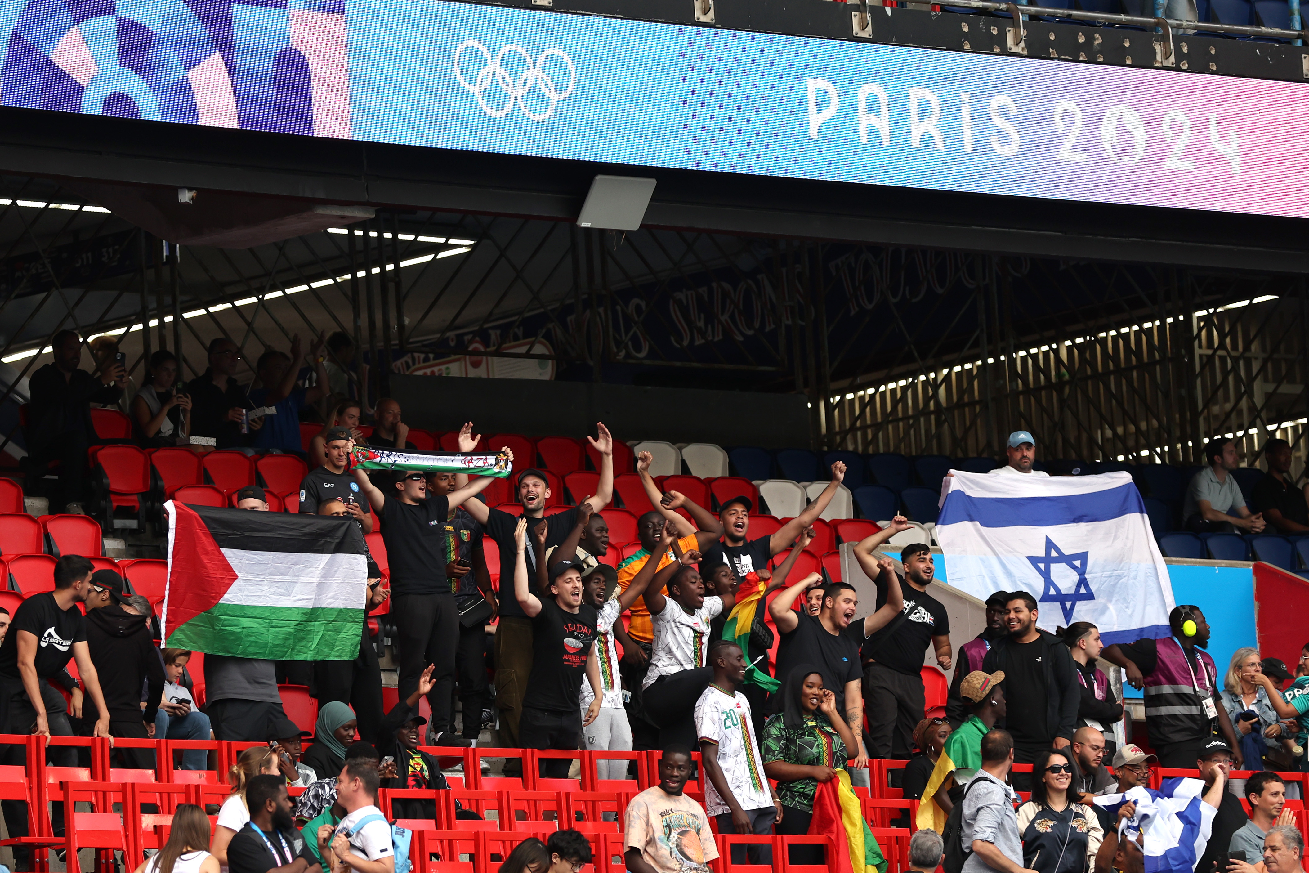 Palestine and Israel fans hold national flags at football match.