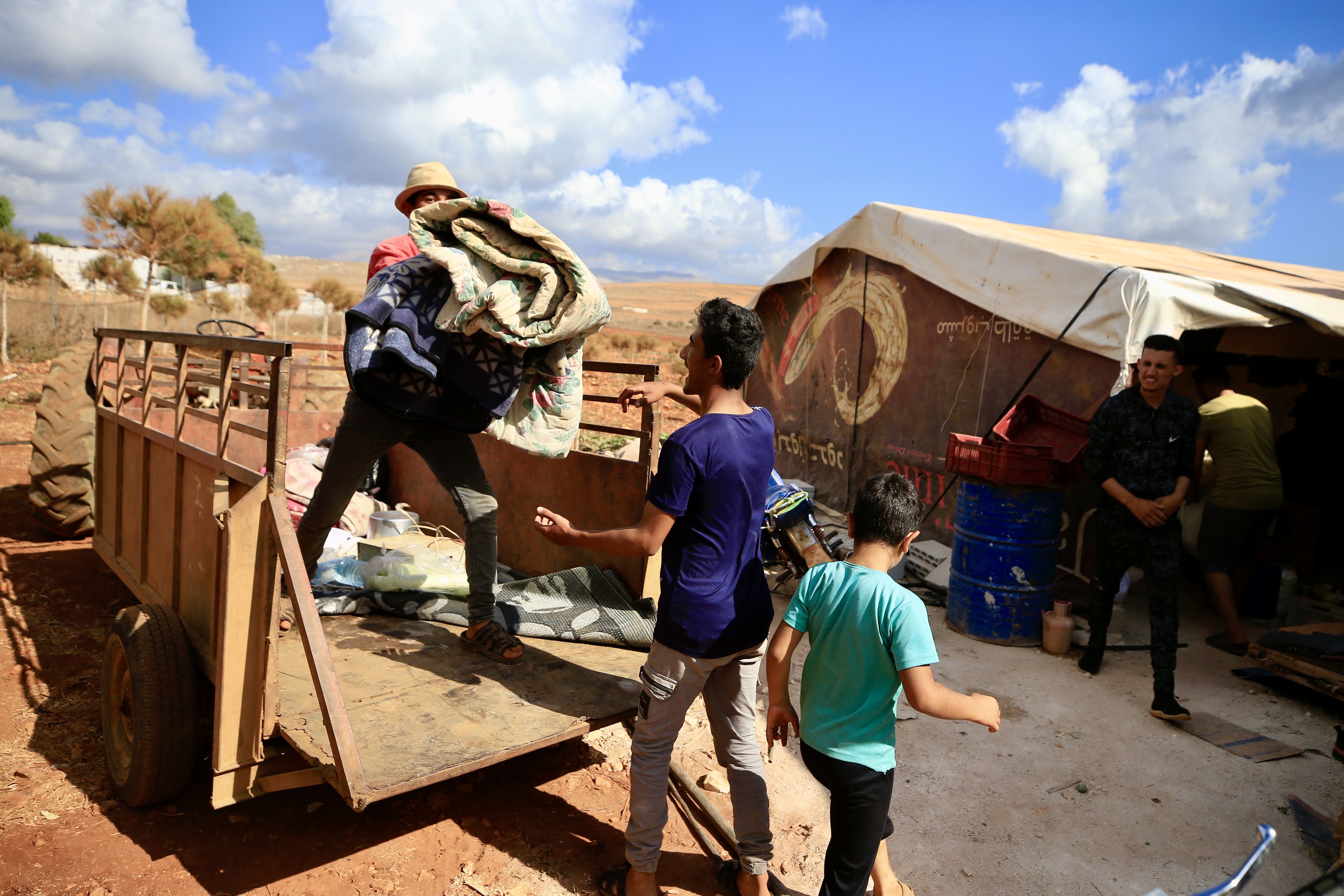 People load their belongings onto trucks