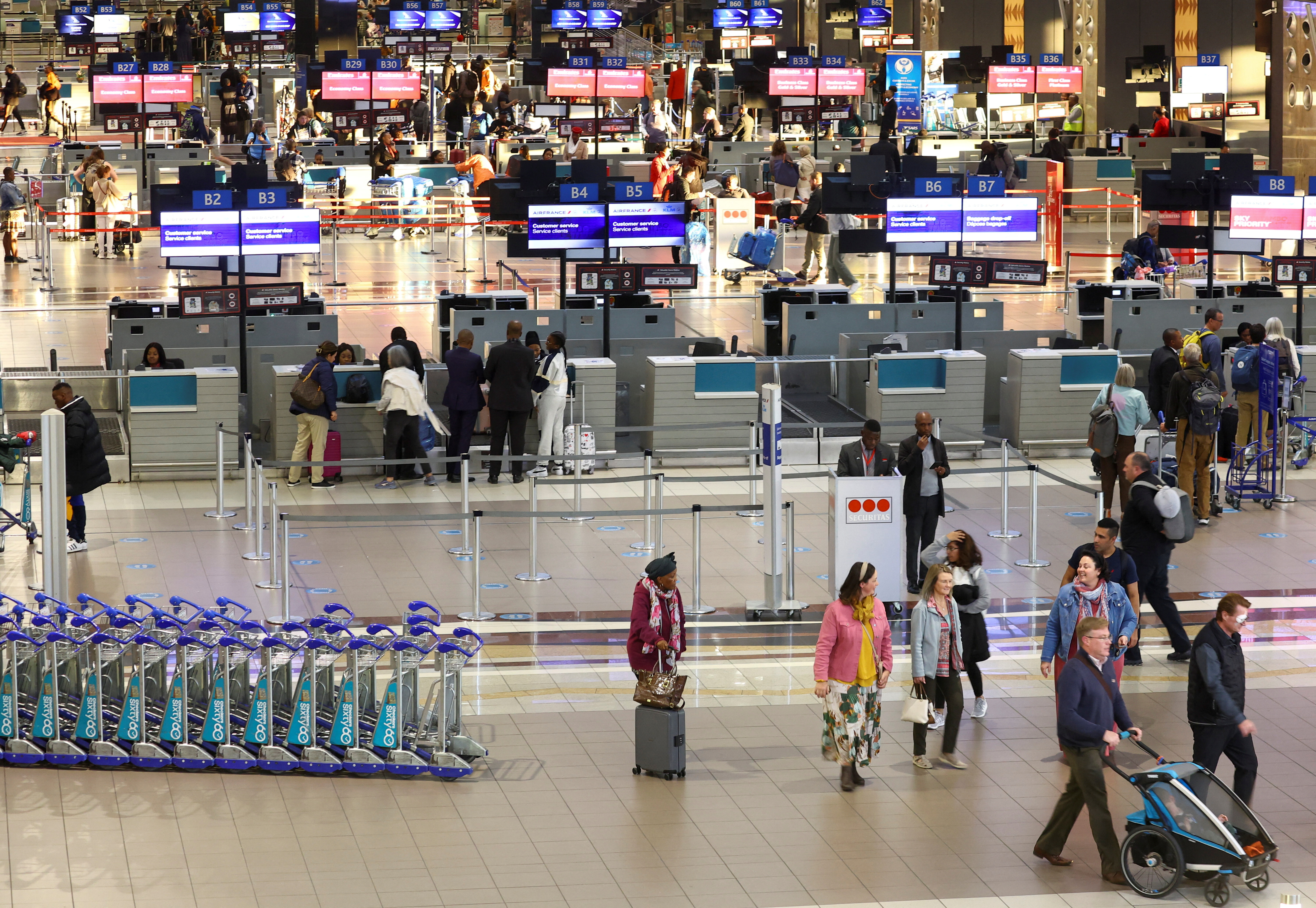 Passengers walk next to check-in counters at the O.R. Tambo International Airport, in Johannesburg, South Africa, July 3, 2023. REUTERS/Siphiwe Sibeko