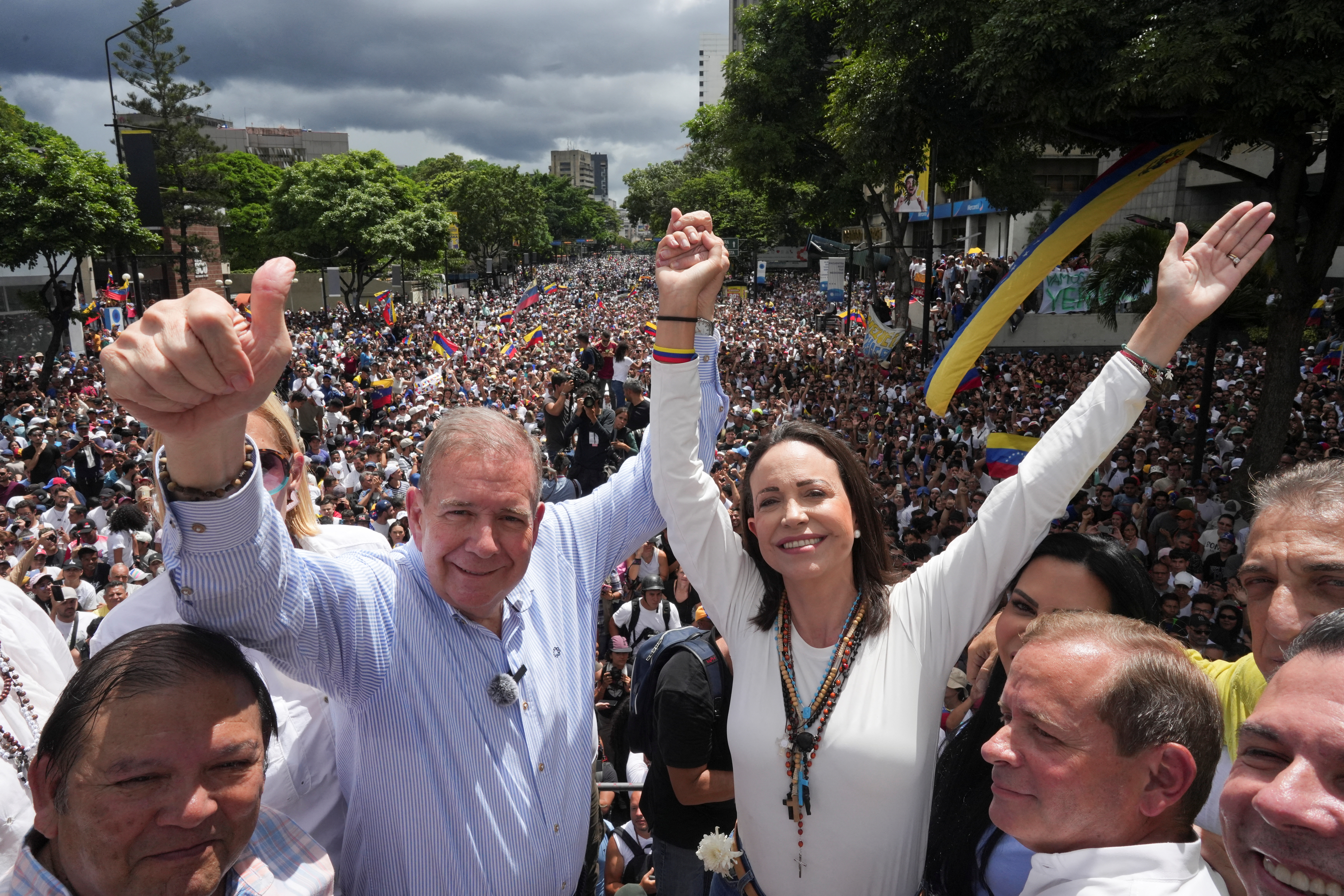 Maria Corina Machado and Edmundo Gonzalez raise their arms during a parade in Venezuela.