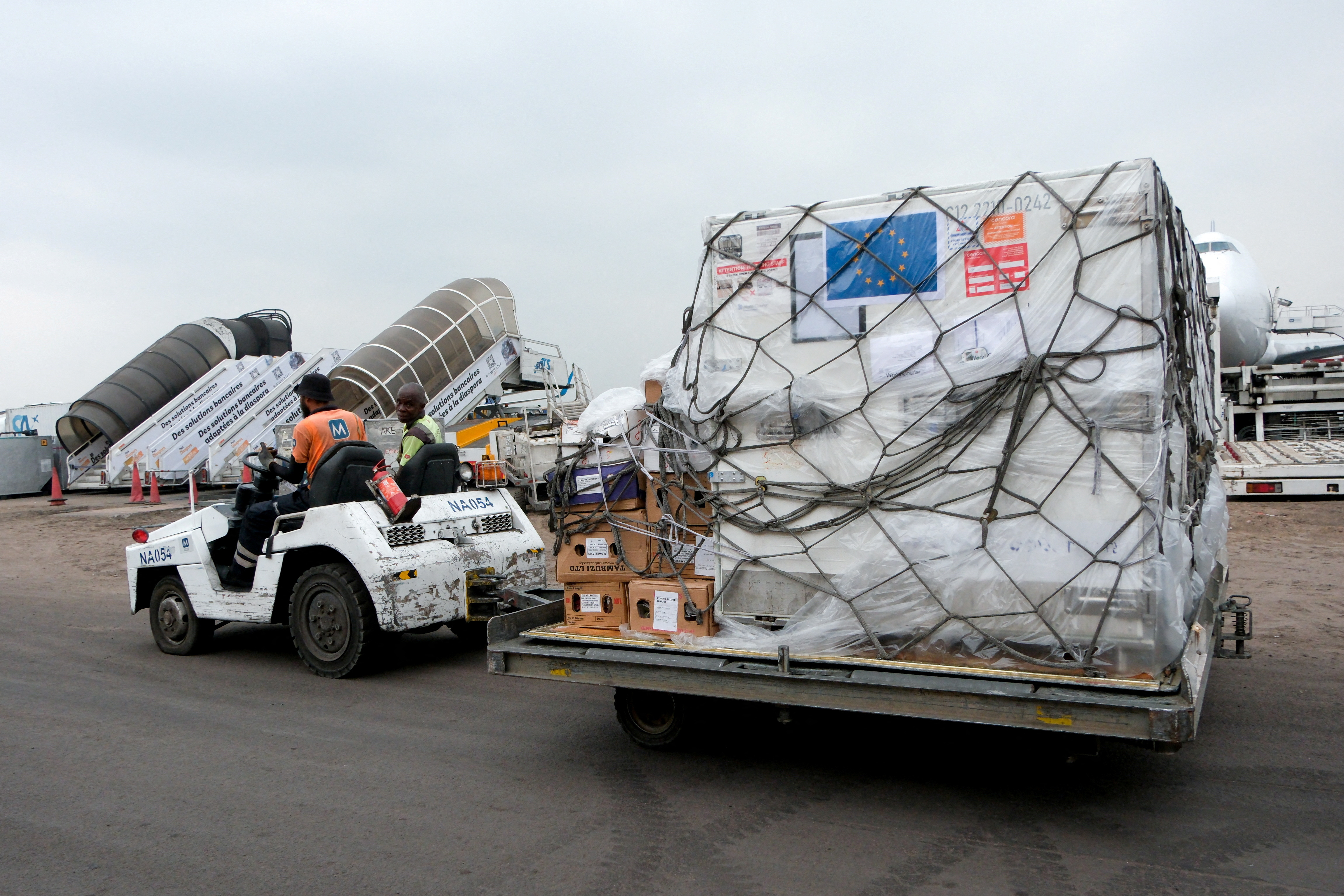 A worker transports mpox vaccines as first batches arrive at N'Djili International Airport in Kinshasa