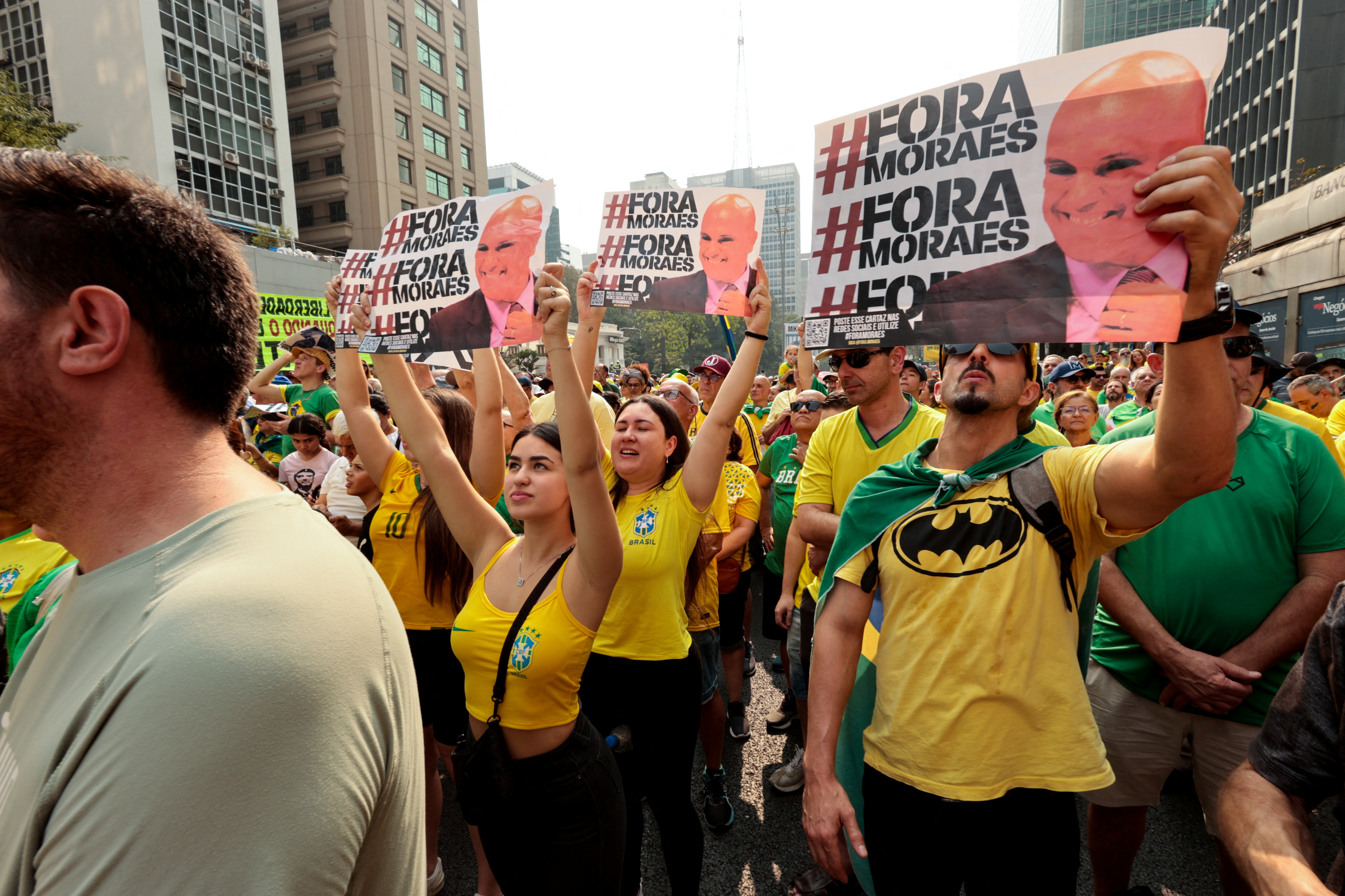 Protesters hold up signs calling on Alexandre de Moraes to leave his post on the Supreme Court.