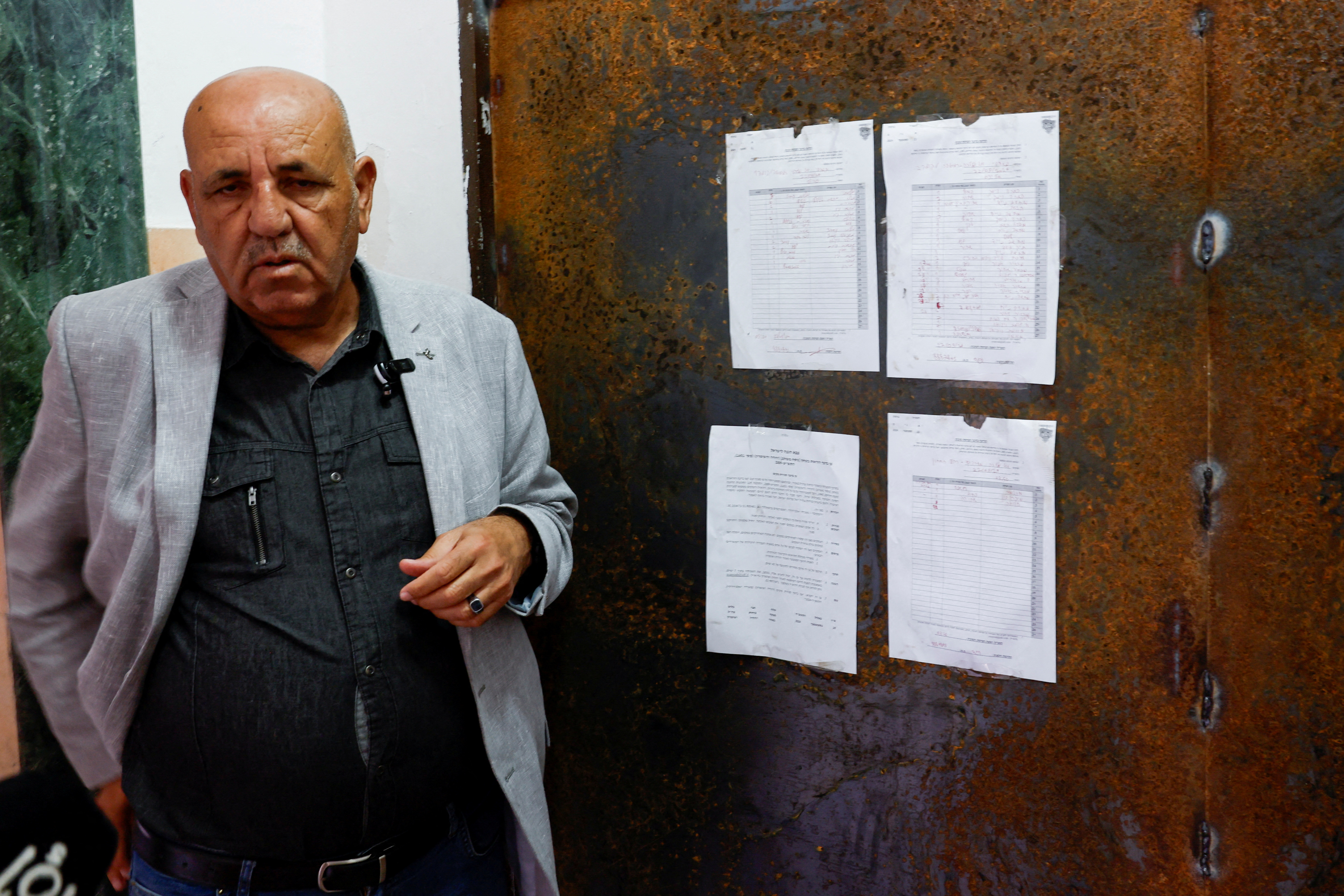 Al Jazeera's local bureau chief Walid al-Omari stands near the entrance to the Al Jazeera office after it was stormed and closed by Israeli forces