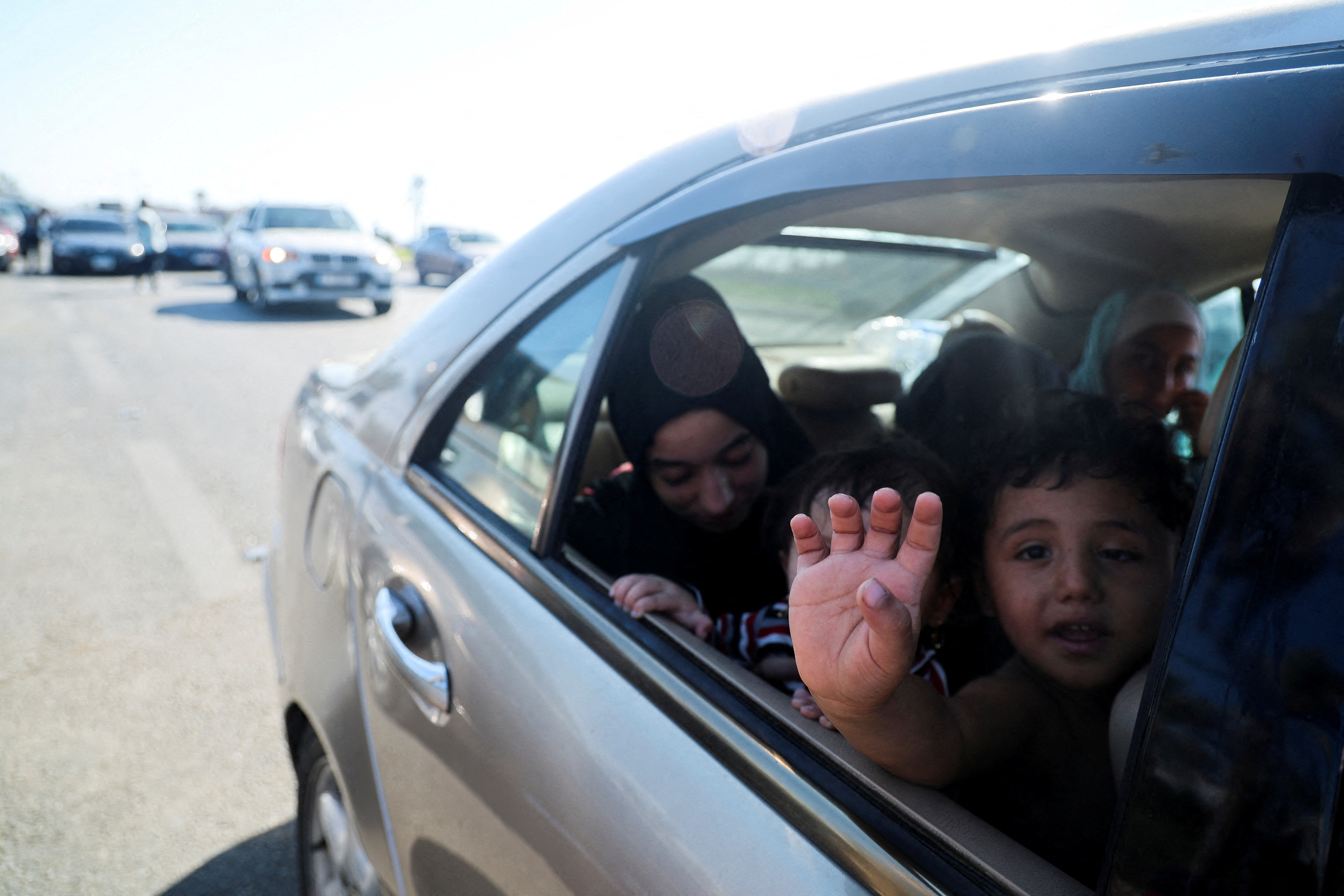 A child gestures from a car in heavy traffic, driving north from Lebanon's southern coastal city Sidon, as people flee Israeli bombardment, in Lebanon on September 23, 2024 [Amr Abdallah Dalsh/Reuters]