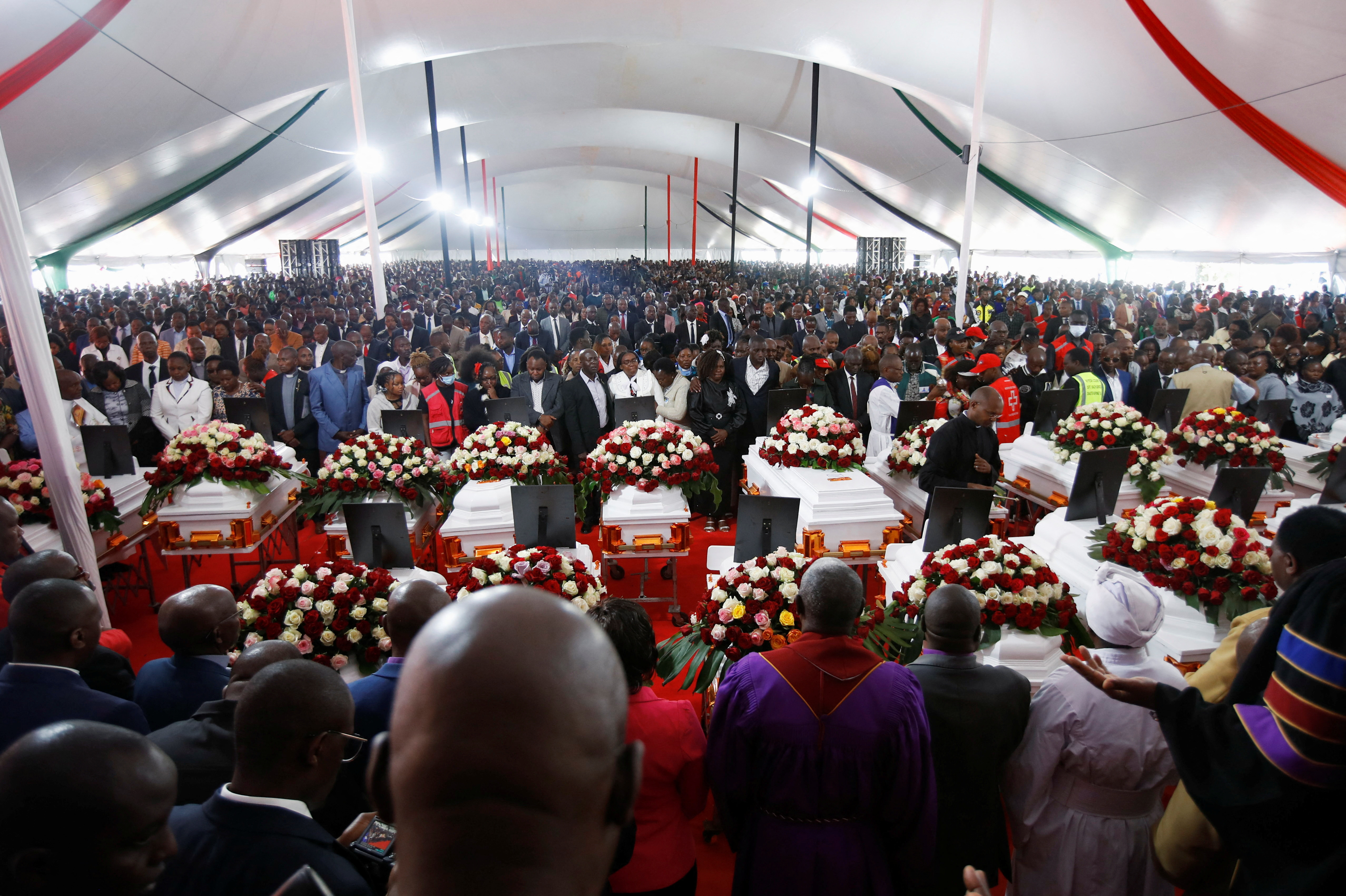 Religious leaders and family members stand next to the coffins during a memorial service for the pupils who died after a fatal fire at the Hillside Endarasha Academy within Kieni in Nyeri County, Kenya September 26, 2024. REUTERS/Monicah Mwangi