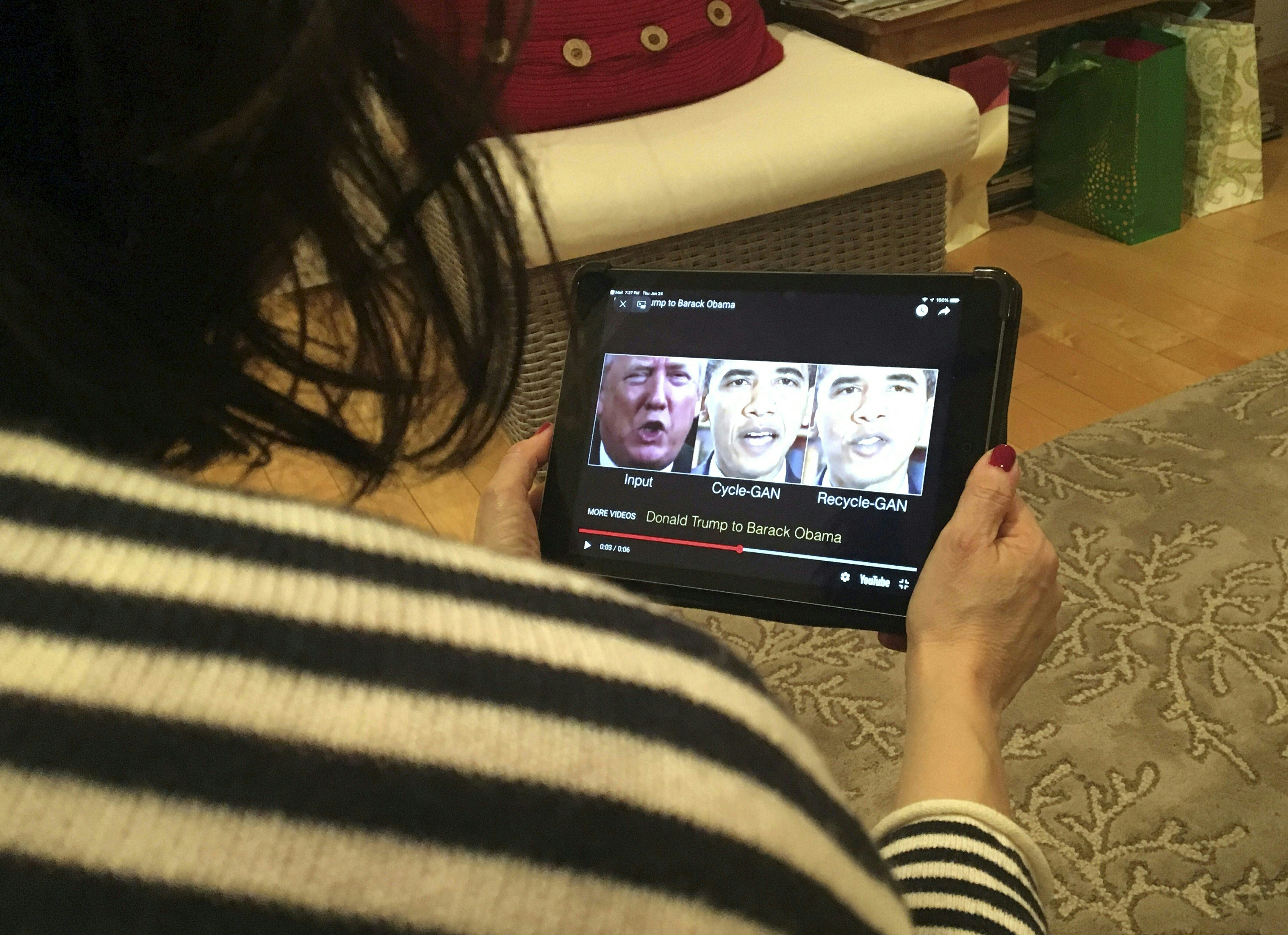 A woman in Washington, DC, views a manipulated video on January 24, 2019, that changes what is said by Donald Trump and former president Barack Obama, illustrating how deepfake technology can deceive viewers. (Rob Lever/AFP)