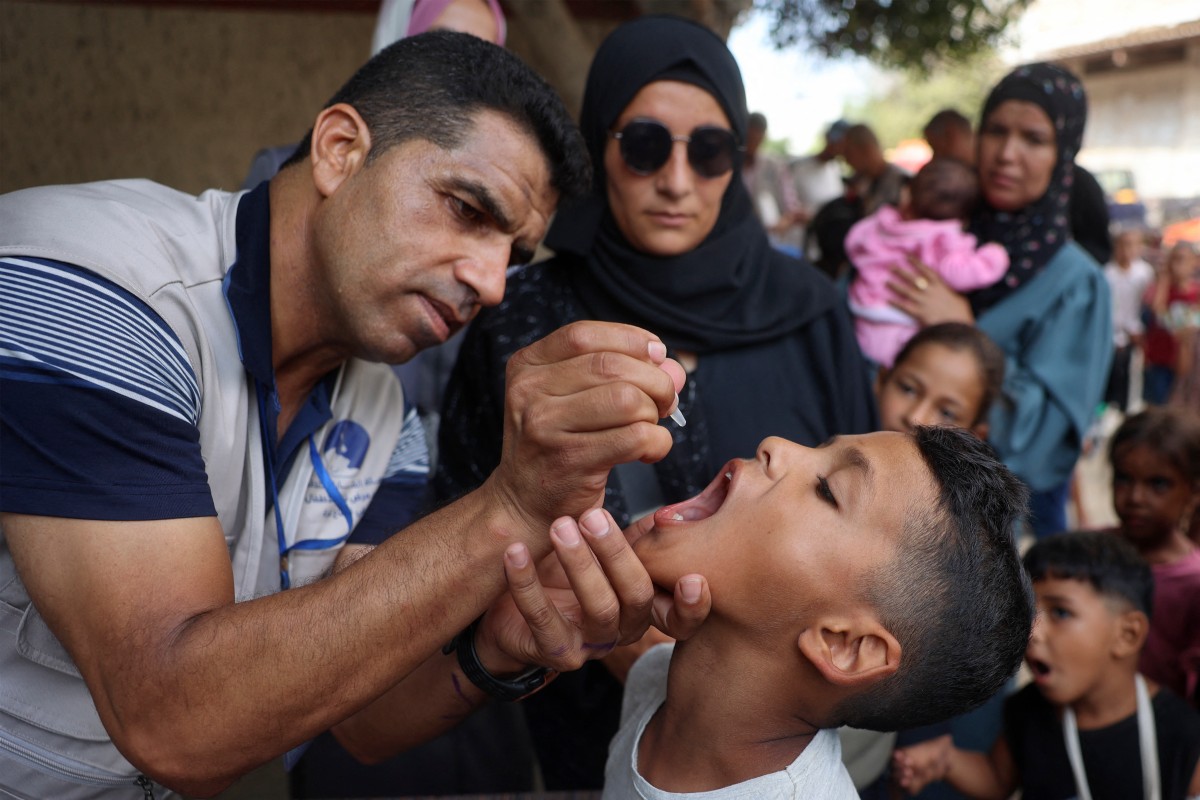A health worker administers the Polio vaccine to a Palestinian child in Zawayda in the central Gaza Strip