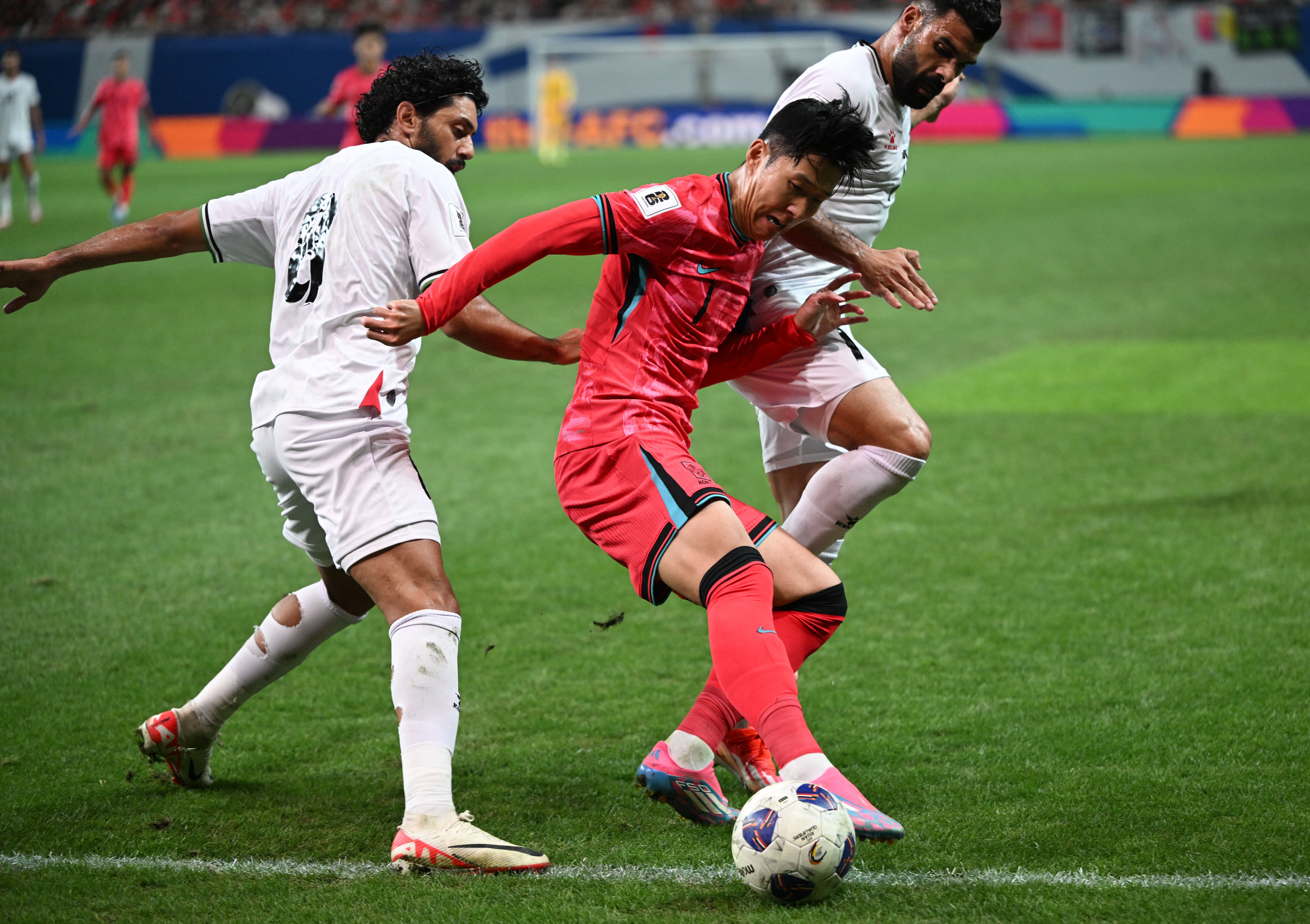South Korea's Son Heung-min (C) fights for the ball with Palestine's Attaa Jaber (L) and Musab Battat (R) during the FIFA World Cup 2026 Asia zone qualifiers football match between South Korea and Palestine in Seoul on September 5, 2024. (Photo by Jung Yeon-je / AFP)