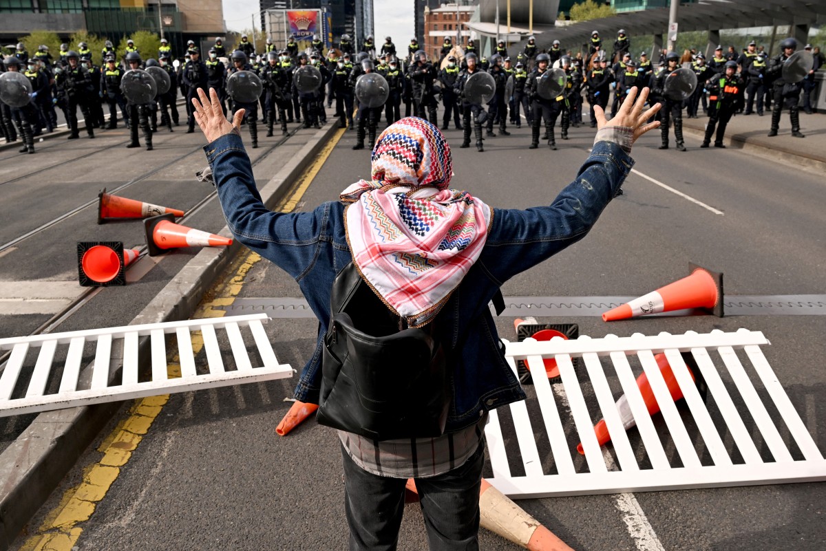 A protester confronts police outside the Land Forces 2024 arms fair in Melbourne
