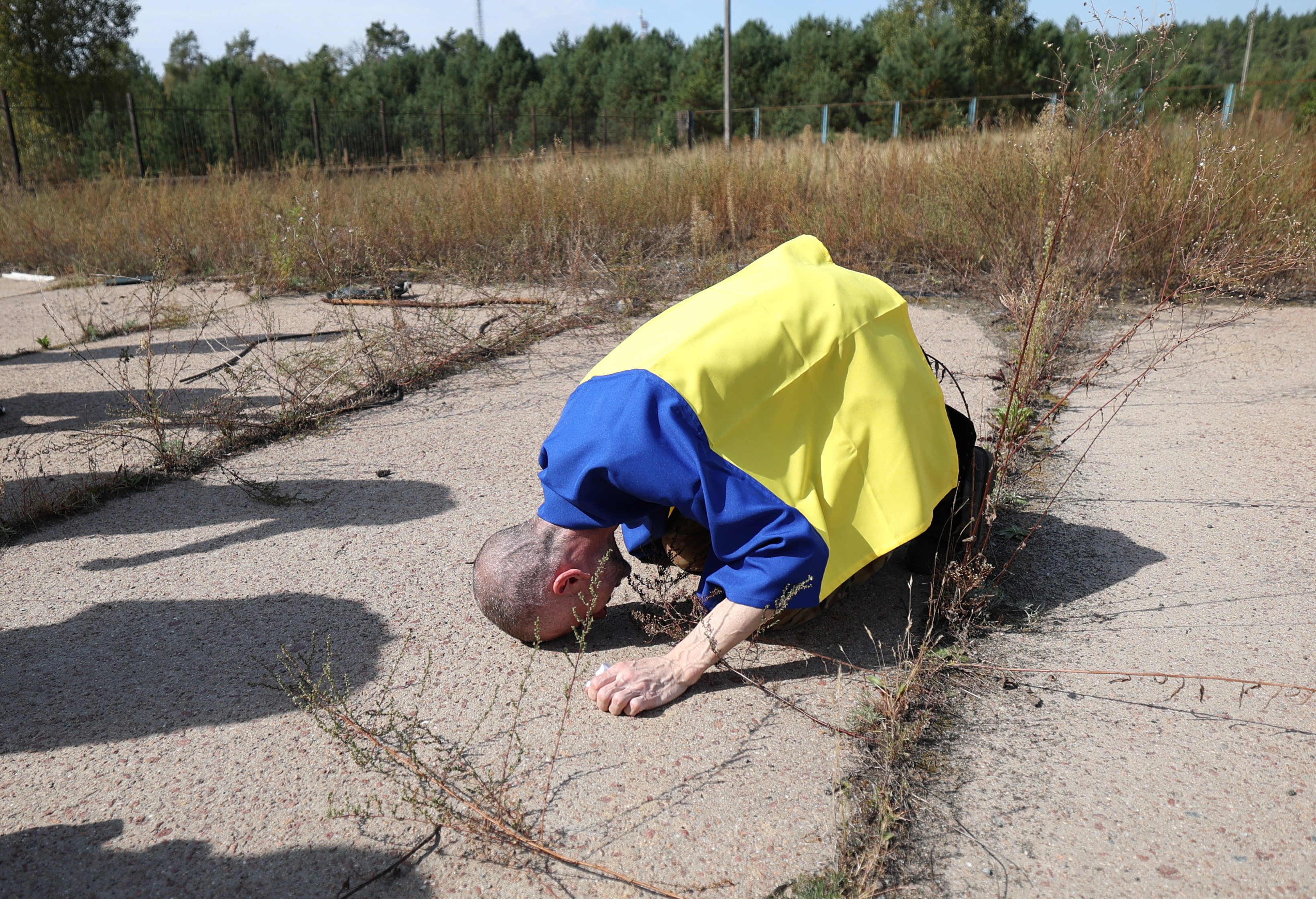 TOPSHOT - A Ukrainian serviceman reacts after being released from Russian captivity at an undisclosed location near the Ukrainian-Belarusian border, on September 13, 2024, amid the Russian invasion in Ukraine. 49 Ukrainian prisoners of war had been returned to their country from Russia on September 13, 2024, with photographs of the men and women wrapped in Ukrainian flags published. (Photo by Anatolii STEPANOV / AFP)