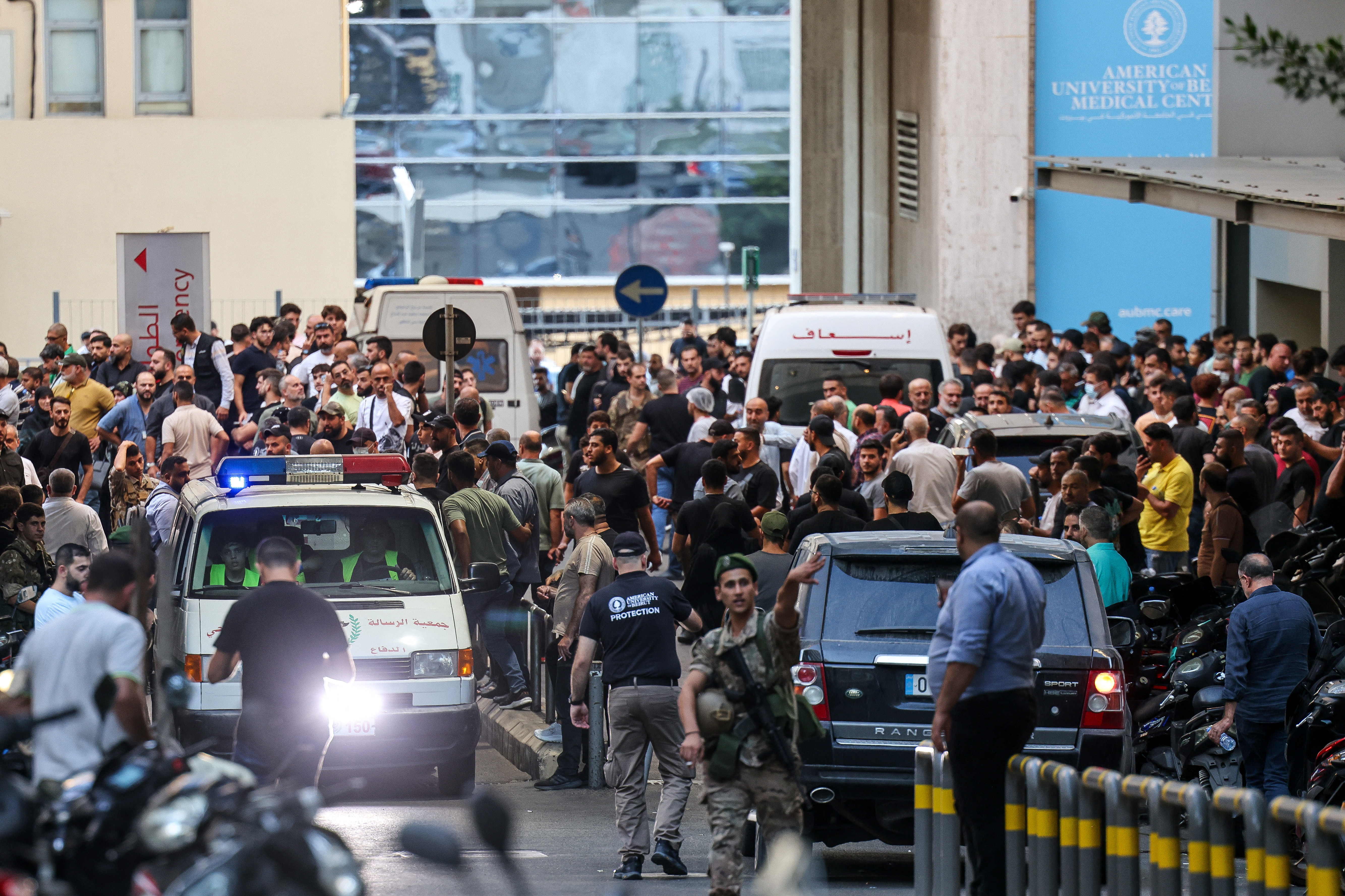 Ambulances are surrounded by people at the entrance of the American University of Beirut Medical Center