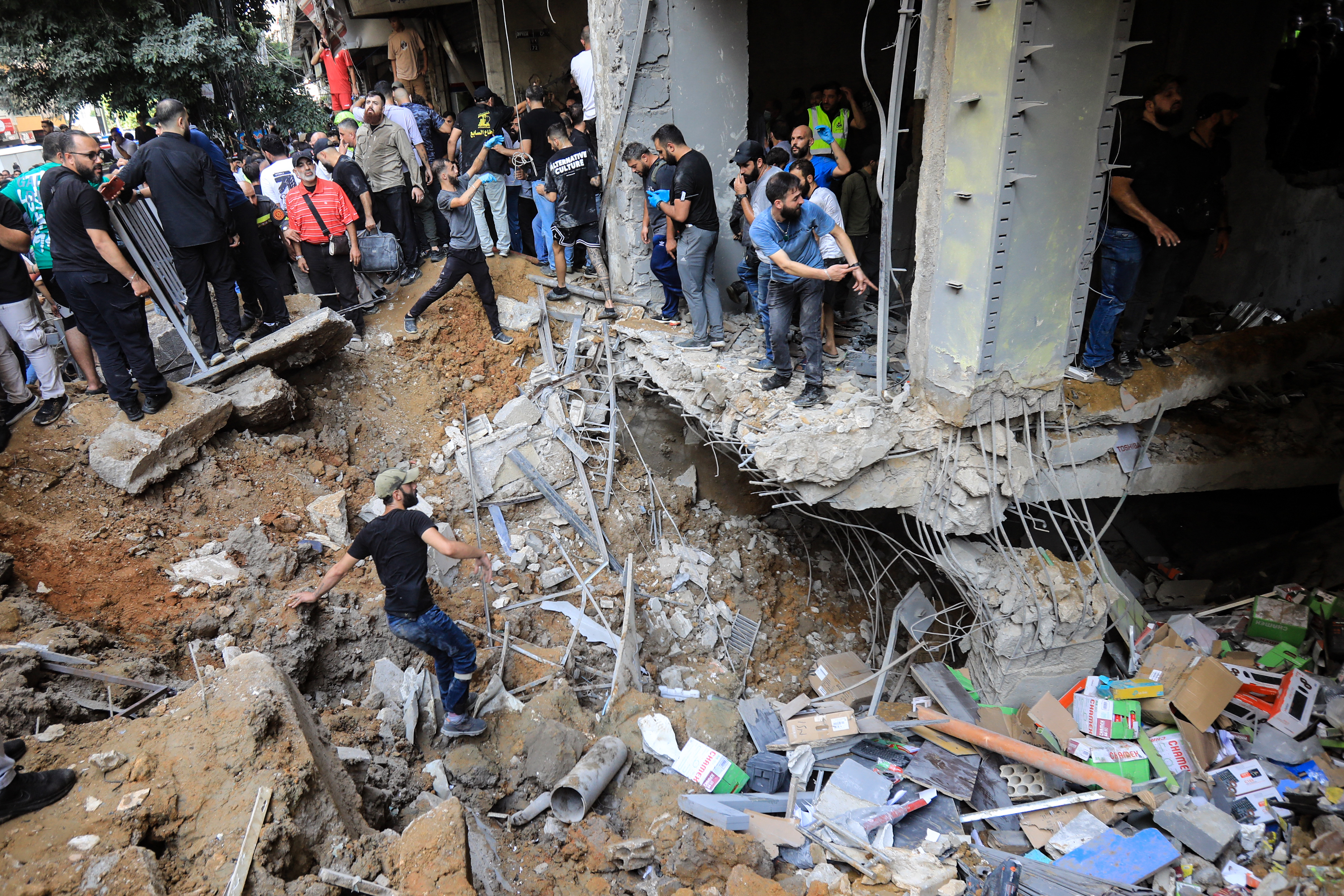 People gather in front of a building hit in an Israeli attack in Beirut