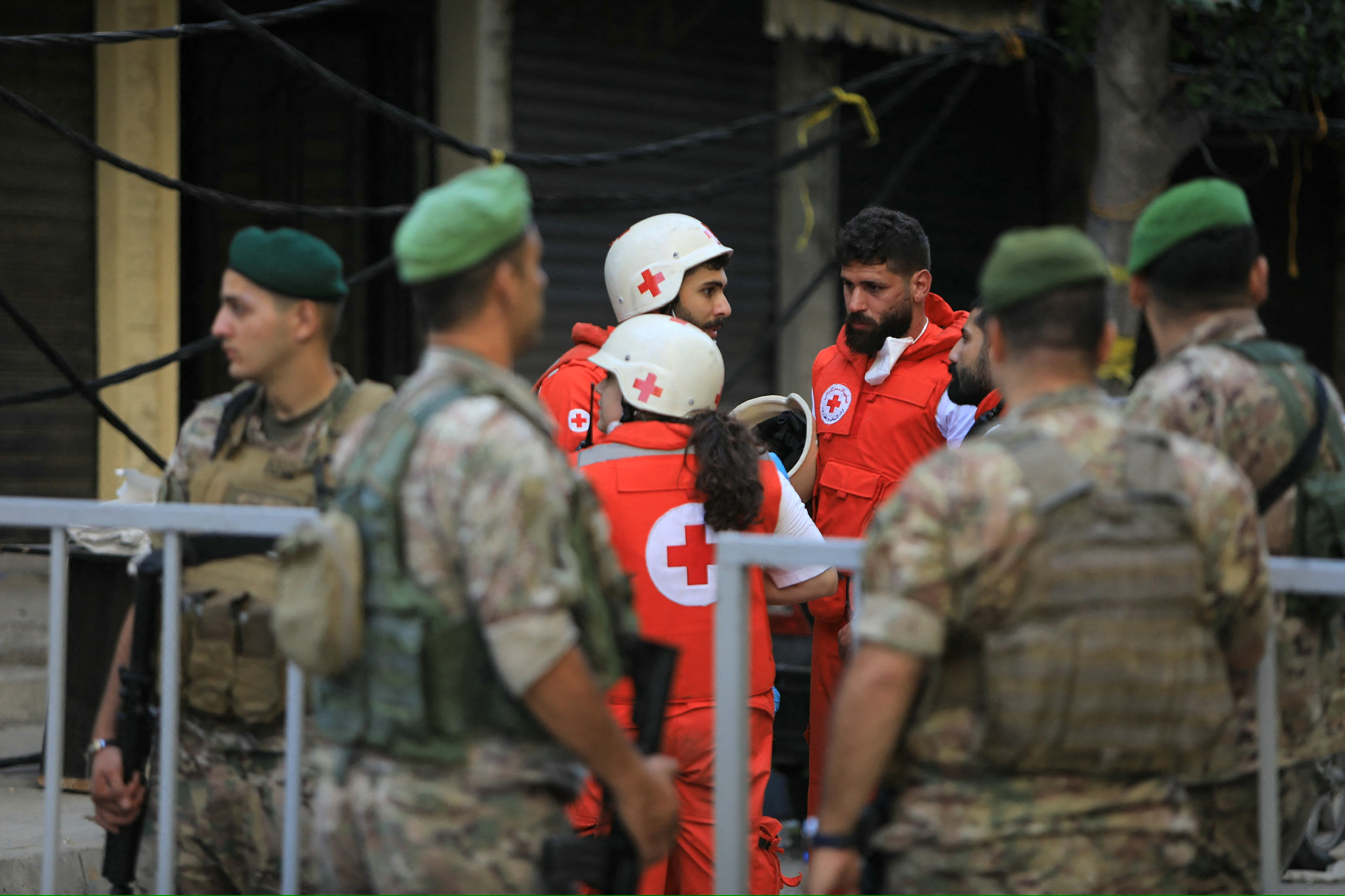 Lebanese army soldiers and Red Cross rescuers gather at the barriered area of the scene of an Israeli strike that targeted Beirut's southern suburbs a day earlier, as search and rescue operations continue on September 21, 2024. - Lebanon's Hezbollah said on September 21 that a second senior commander was among 16 fighters killed in an Israeli air strike on its Beirut stronghold the previous day, highlighting the scale of the blow to its military leadership. (Photo by AFP)