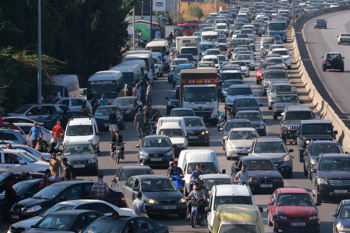 Vehicles wait in traffic in the town of Damour, south of the capital Beirut on September 24, 2024, as people flee southern Lebanon. - Israel announced dozens of new air strikes on Hezbollah strongholds in Lebanon on September 24, a day after 492 people, including 35 children, were killed in the deadliest bombardment since a devastating war in 2006. (Photo by Ibrahim AMRO / AFP)