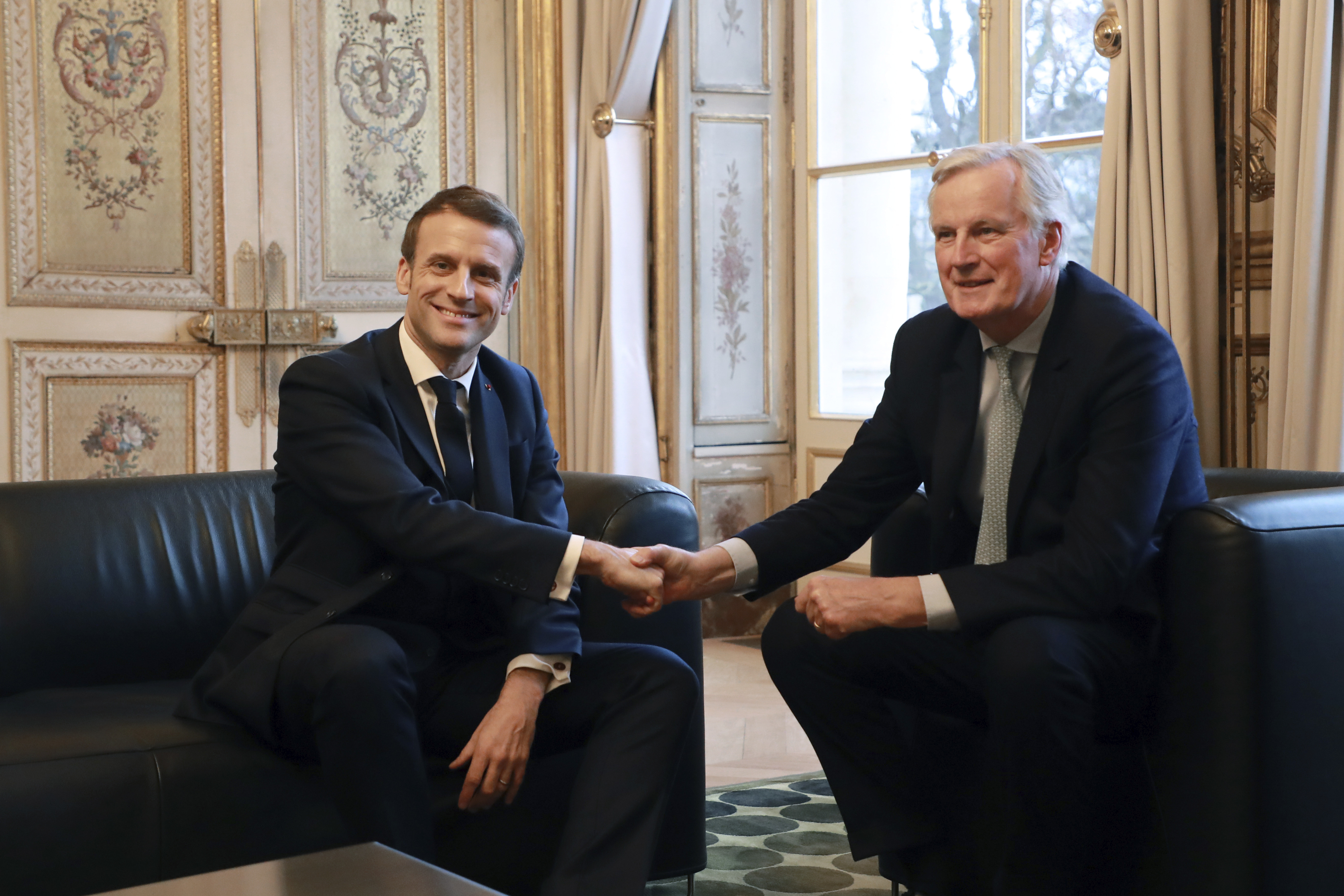 French President Emmanuel Macron, left, shakes hands with European Union chief Brexit negotiator Michel Barnier at the Elysee Palace in Paris, Friday, Jan. 31, 2020. The U.K. is due to leave the EU on Friday the first nation in the bloc to do so. (Ludovic Marin/Pool Photo via AP)