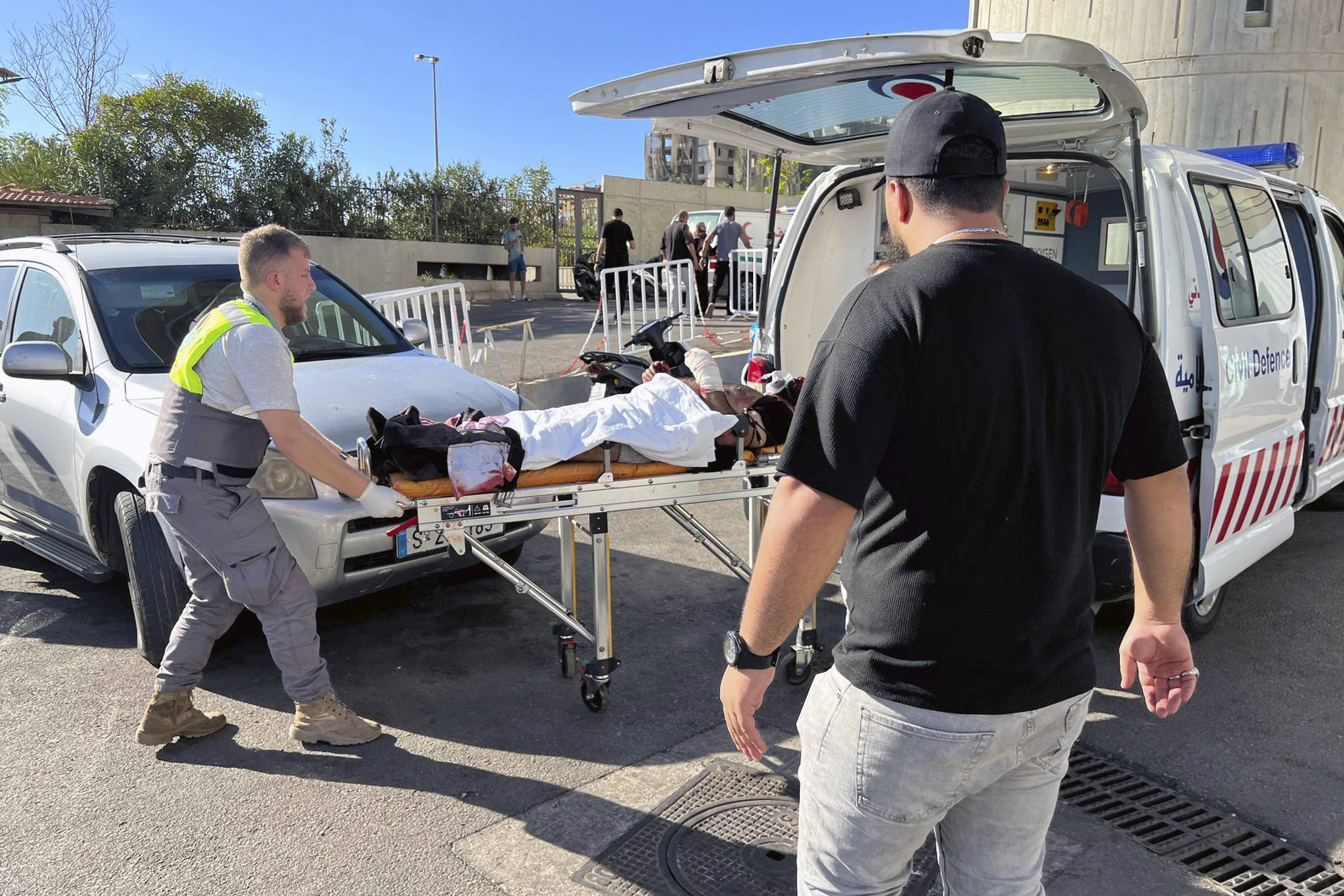 Civil Defense first-responders carry a wounded man whose handheld pager exploded at al-Zahraa hospital in Beirut