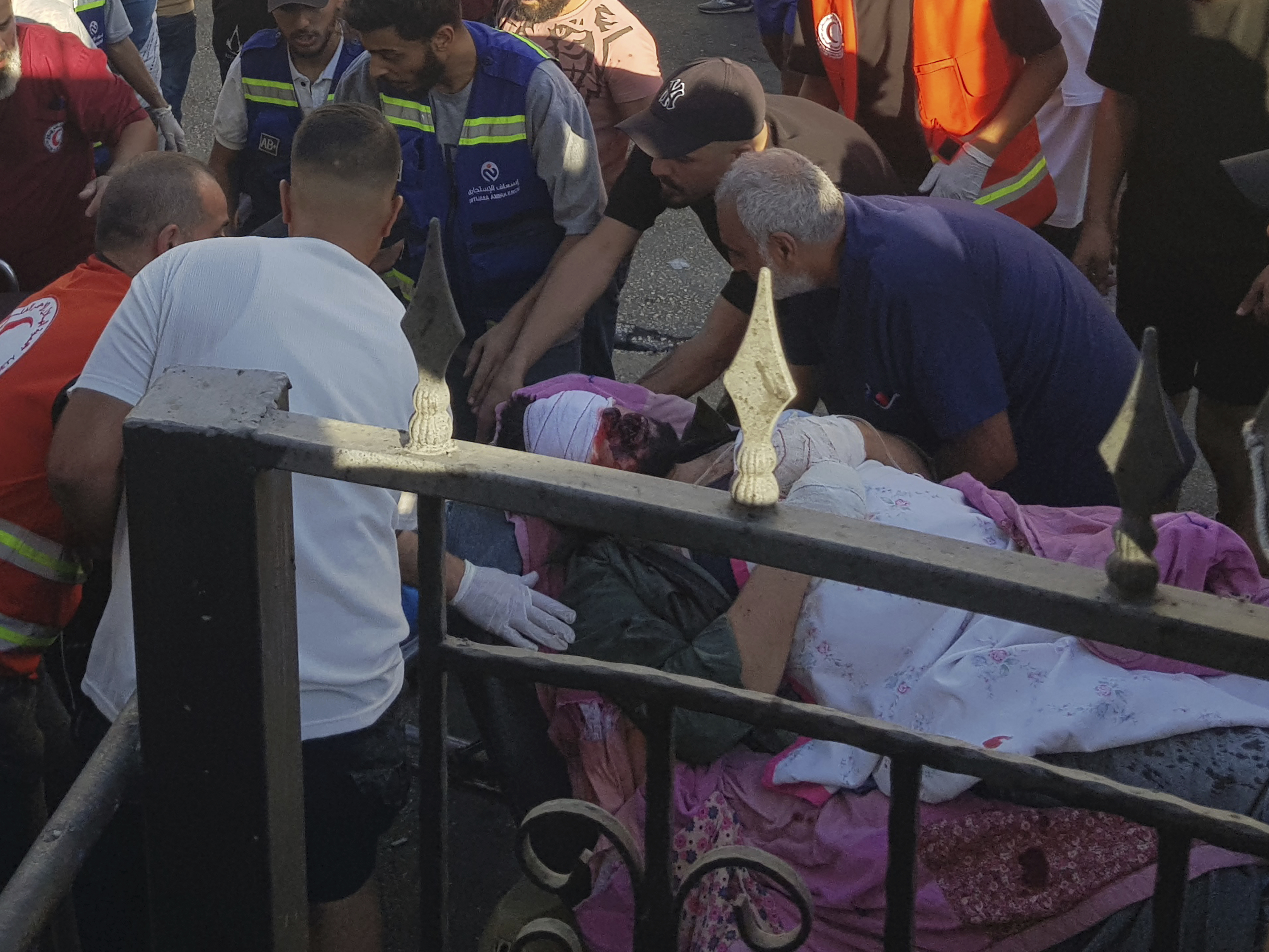 Civil Defense first-responders carry a man who was wounded after his handheld pager exploded