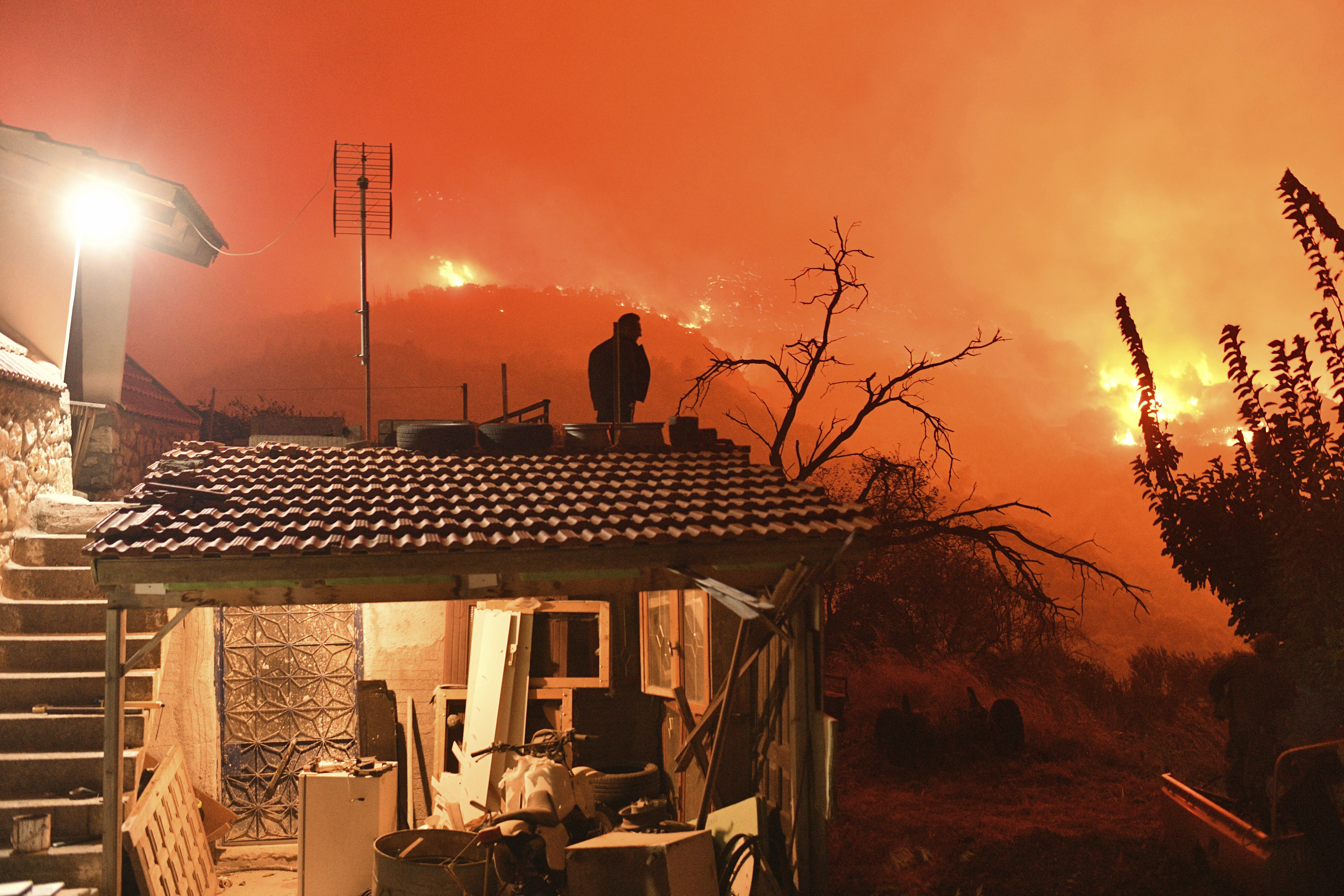 A wildfire approaches the village of Kallithea as fanned by strong winds raged uncontrolled despite the attempts of hundreds of firefighters to stop it, some 149 kilometers (93 miles) west of Athens, Greece, in the region of Corinthia, late Sunday, Sept. 29