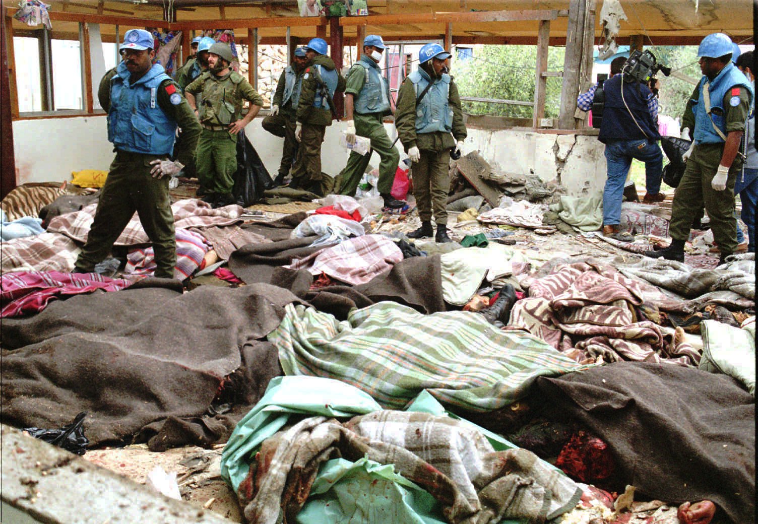 FILE - In this Thursday, April 18, 1996 file photo, the bodies of Muslim refugees are covered by blankets at the headquarters of the Fijian battalion attached to the United Nations Peacekeeping forces, in the village of Qana, Lebanon. Israel shelled the United Nations compound, killing 106 civilians. Hundreds of Lebanese civilians were using the compound to escape fighting between militant Hezbollah fighters and Israel. (AP Photo)