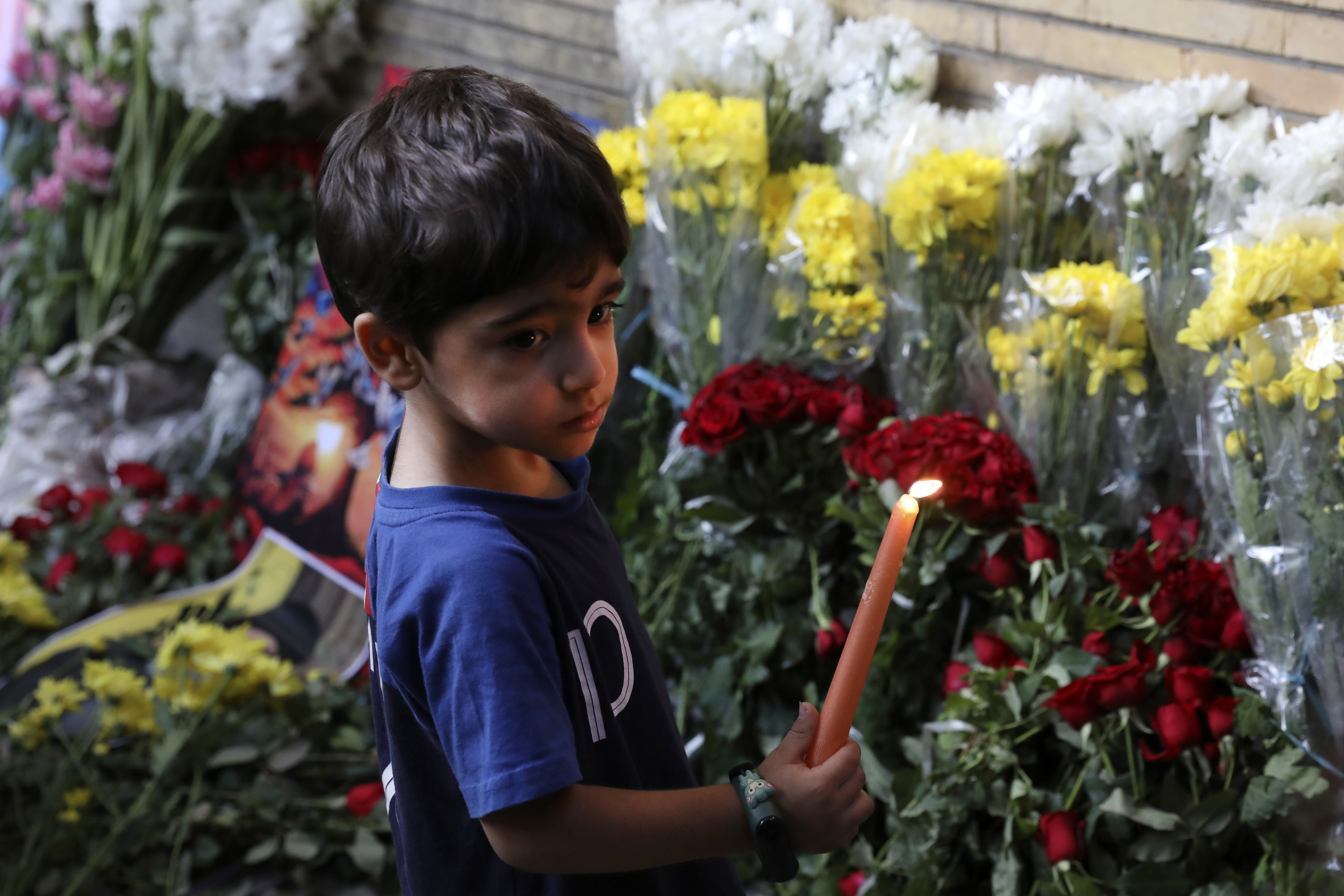 A young boy holds a candle in front of the Lebanese Embassy in Tehran, Iran, Wednesday, Sept. 18, 2024. (AP Photo/Vahid Salemi)