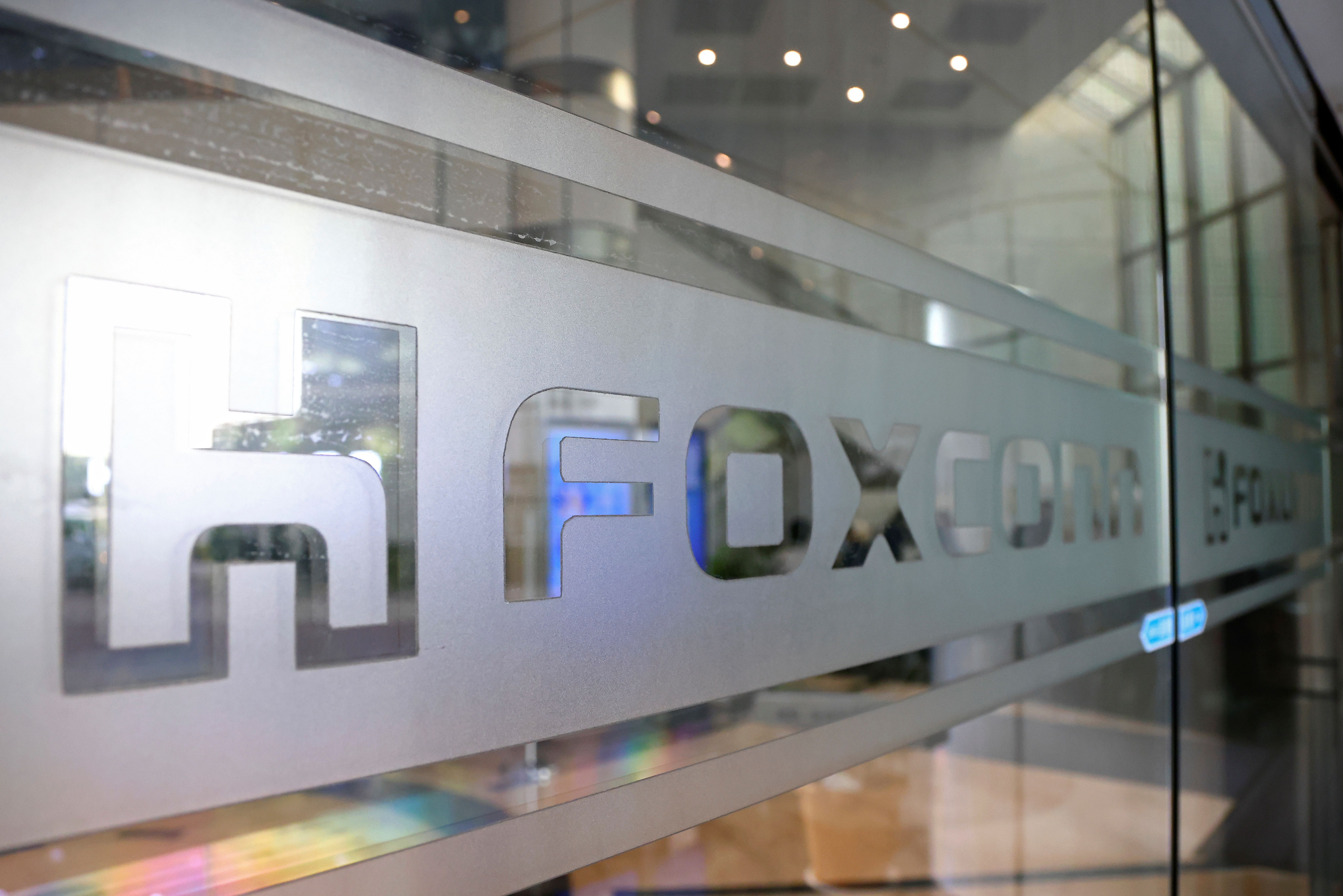 A sign of Foxconn is seen at a glass door inside its office building in Taipei, Taiwan.