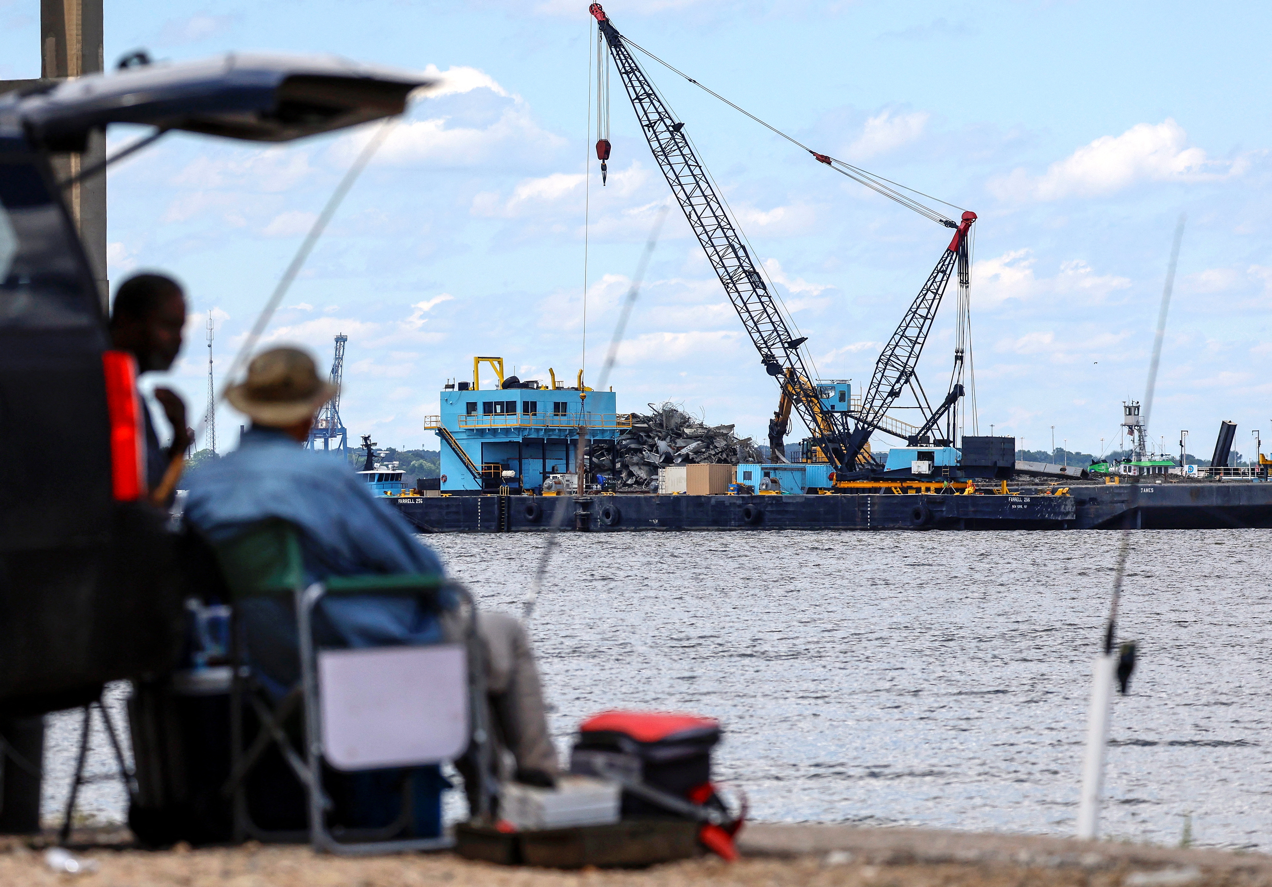 Men fish at Fort Armistead Park while clean-up operations continue around the Francis Scott Key Bridge as the main shipping channel prepares to fully reopen, in Baltimore, Maryland, U.S., June 10, 2024. REUTERS/Evelyn Hockstein