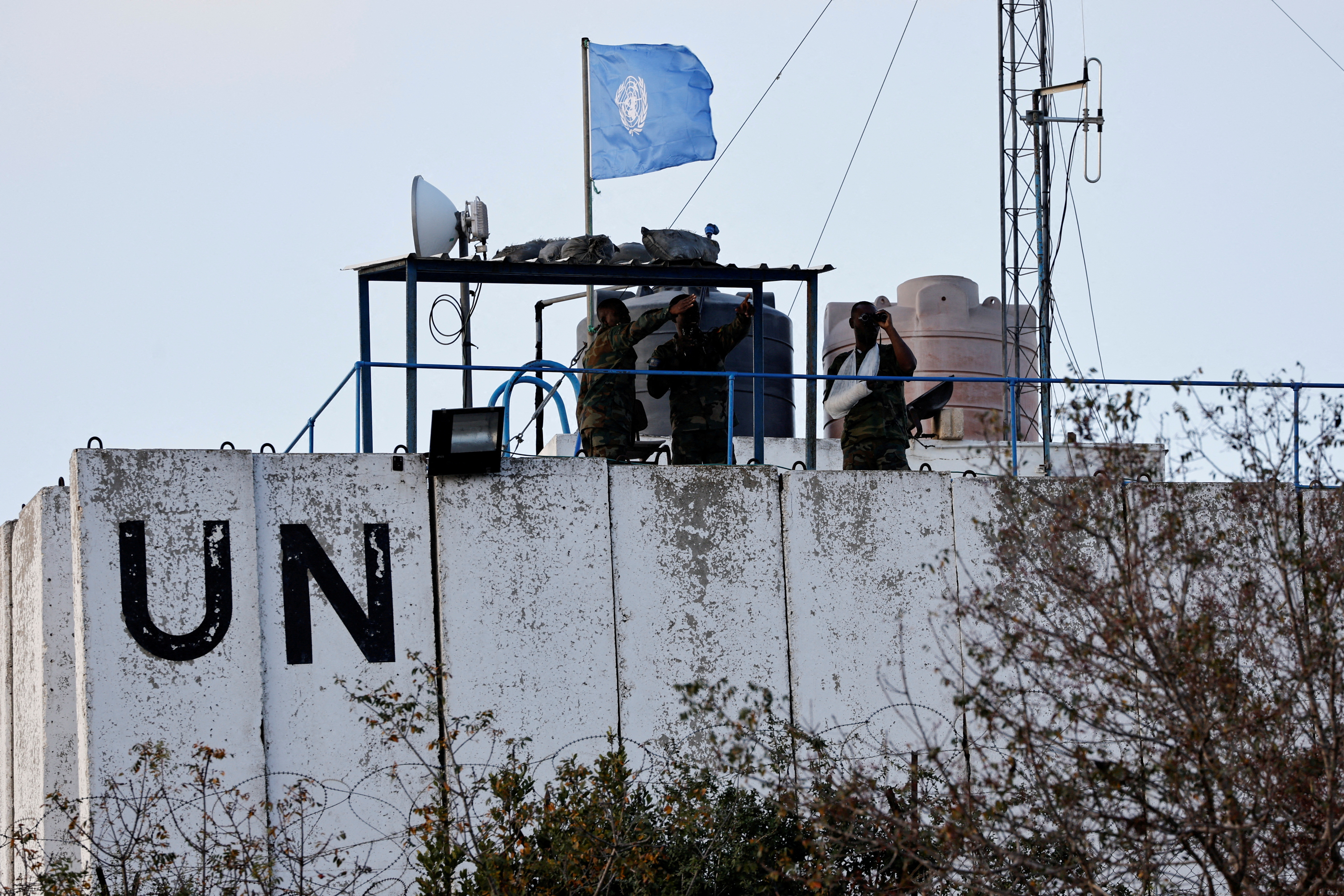 Members of the United Nations peacekeepers (UNIFIL) look at the Lebanese-Israeli border, as they stand on the roof of a watch tower ‏in the town of Marwahin, in southern Lebanon