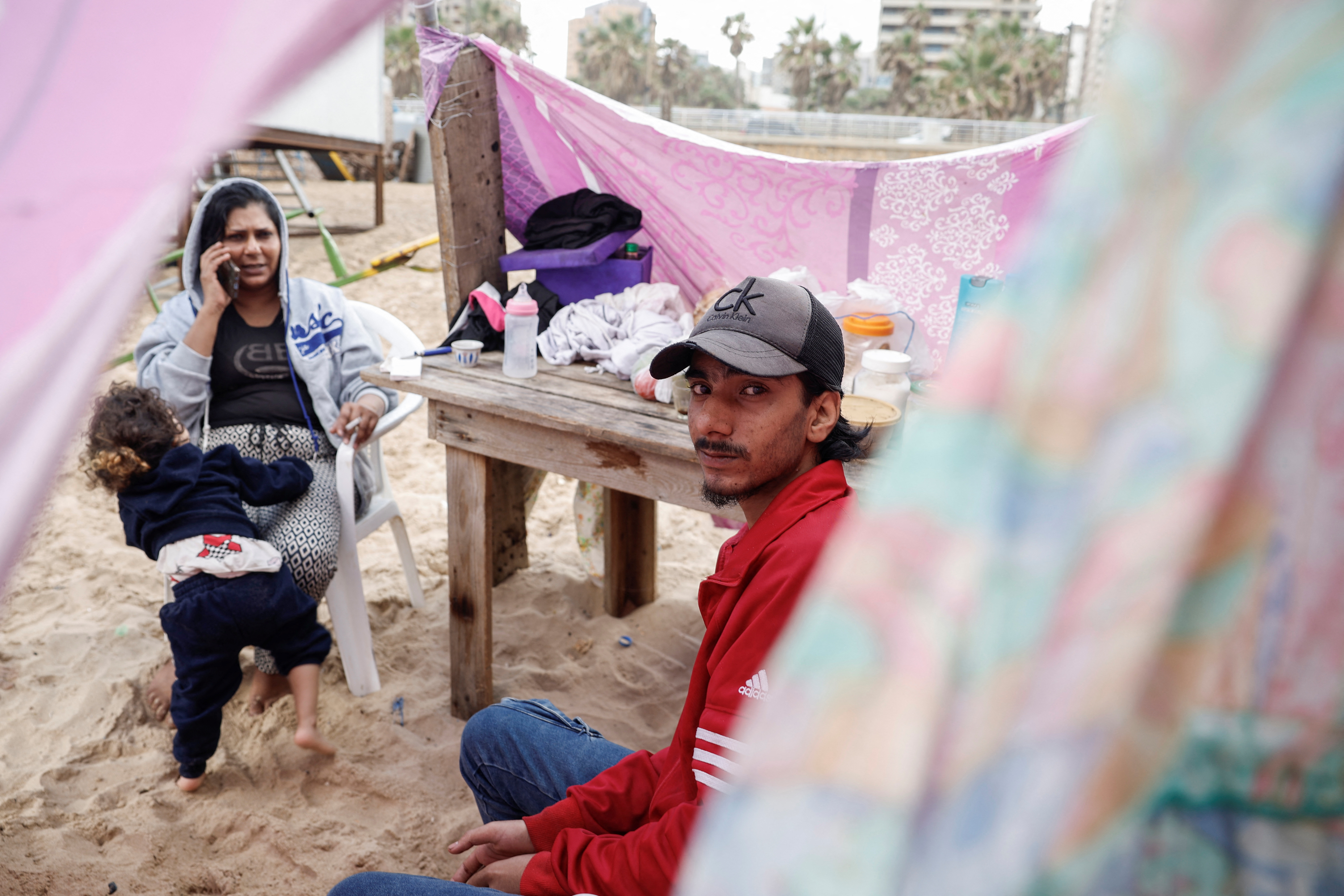 A Syrian family shelters at a makeshift encampment where scores of displaced people live, amid cross-border hostilities between Hezbollah and Israeli forces, at a beach in Beirut, Lebanon, October 1