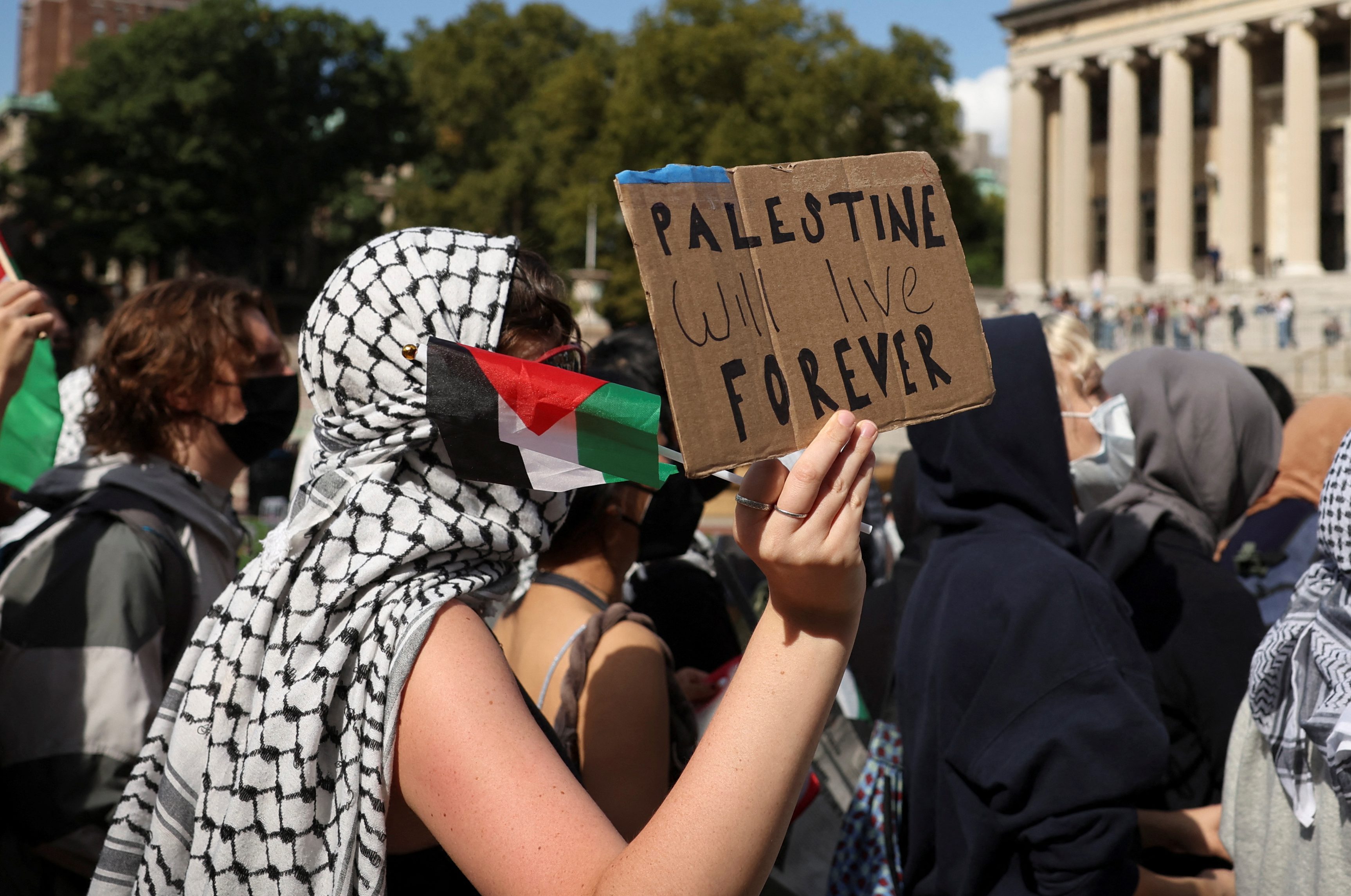 A demonstrator holds a sign that reads "Palestine will live forever", on the campus of Columbia University.