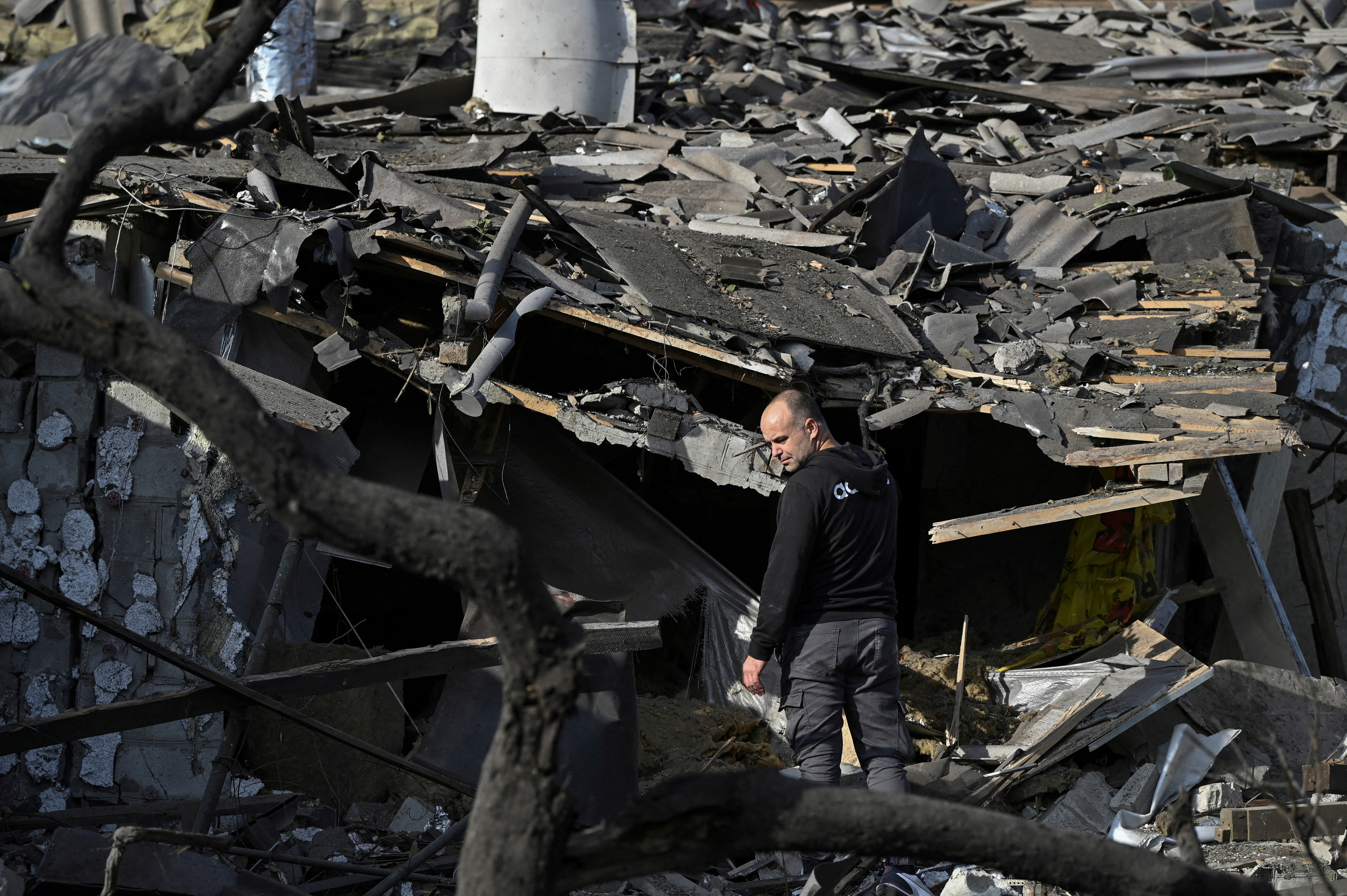A man outside his destroyed house in Zaporizhia. The house is a pile of blackened debris