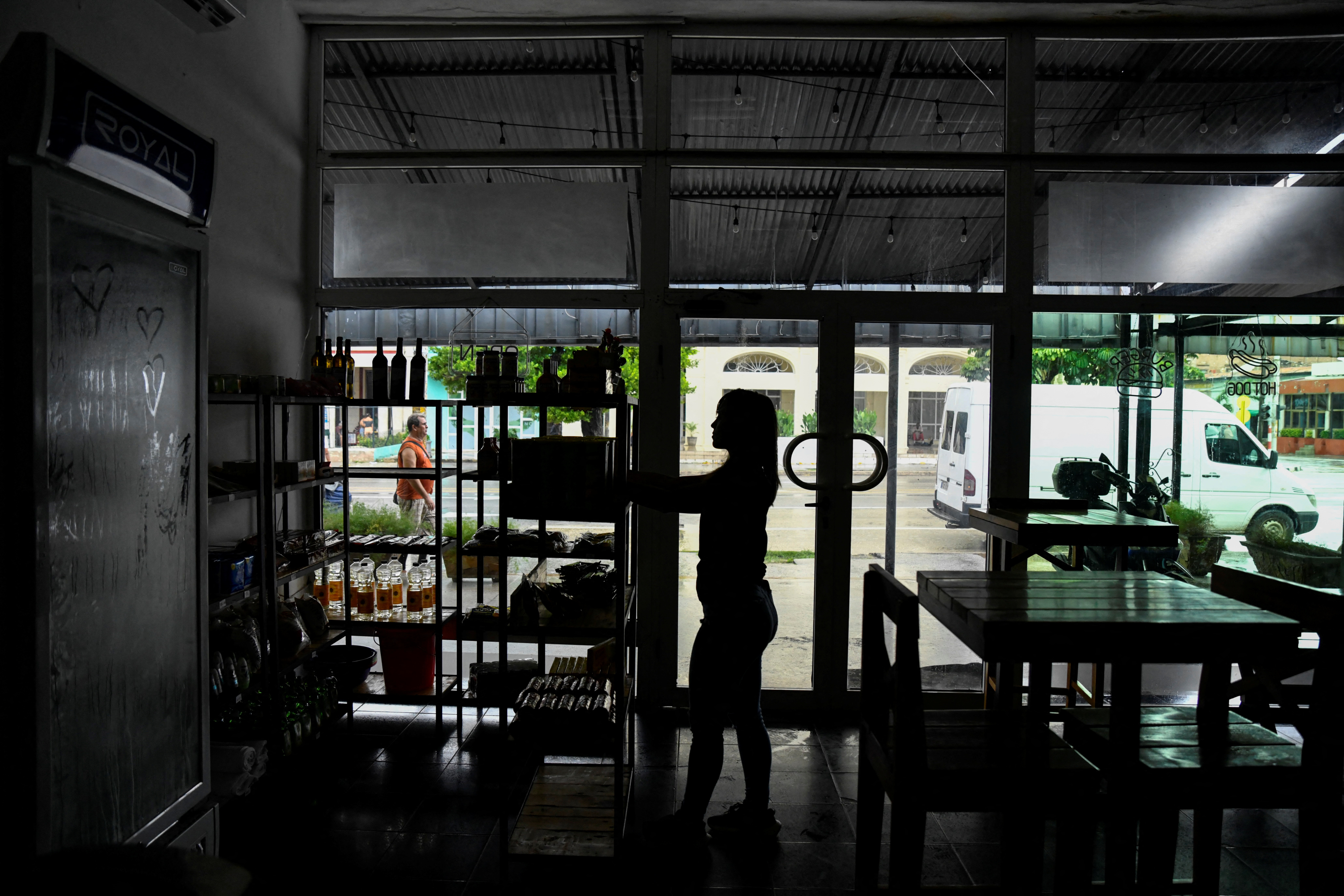 A woman works in a restaurant during a blackout in Havana, Cuba, October 17, 2024. REUTERS/Norlys Perez