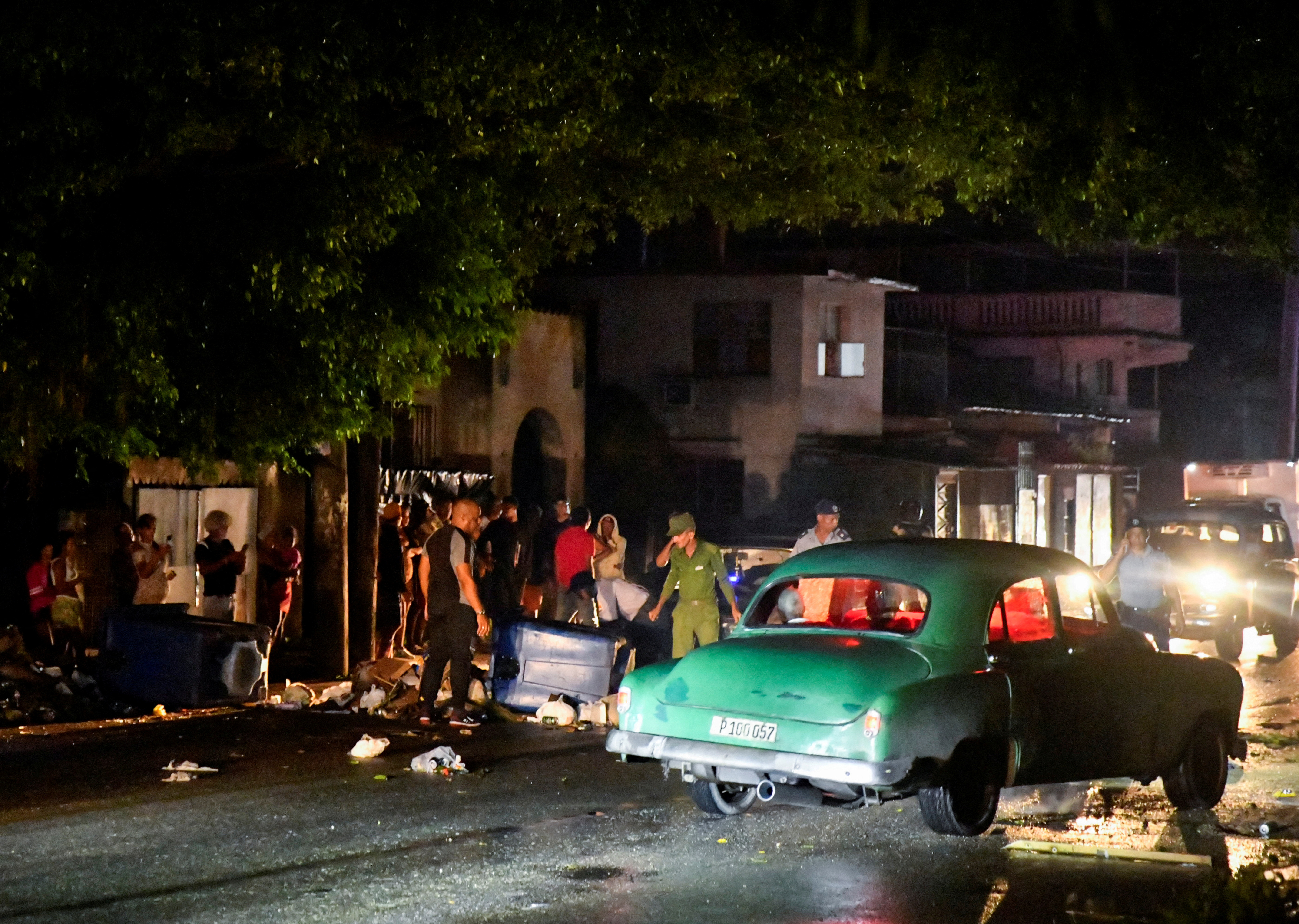 FILE PHOTO: Cuban police and military stand next to debris used to block a street during a protest against a blackout, after opening the street up to traffic, in Havana, Cuba October 19, 2024. REUTERS/Norlys Perez/File Photo