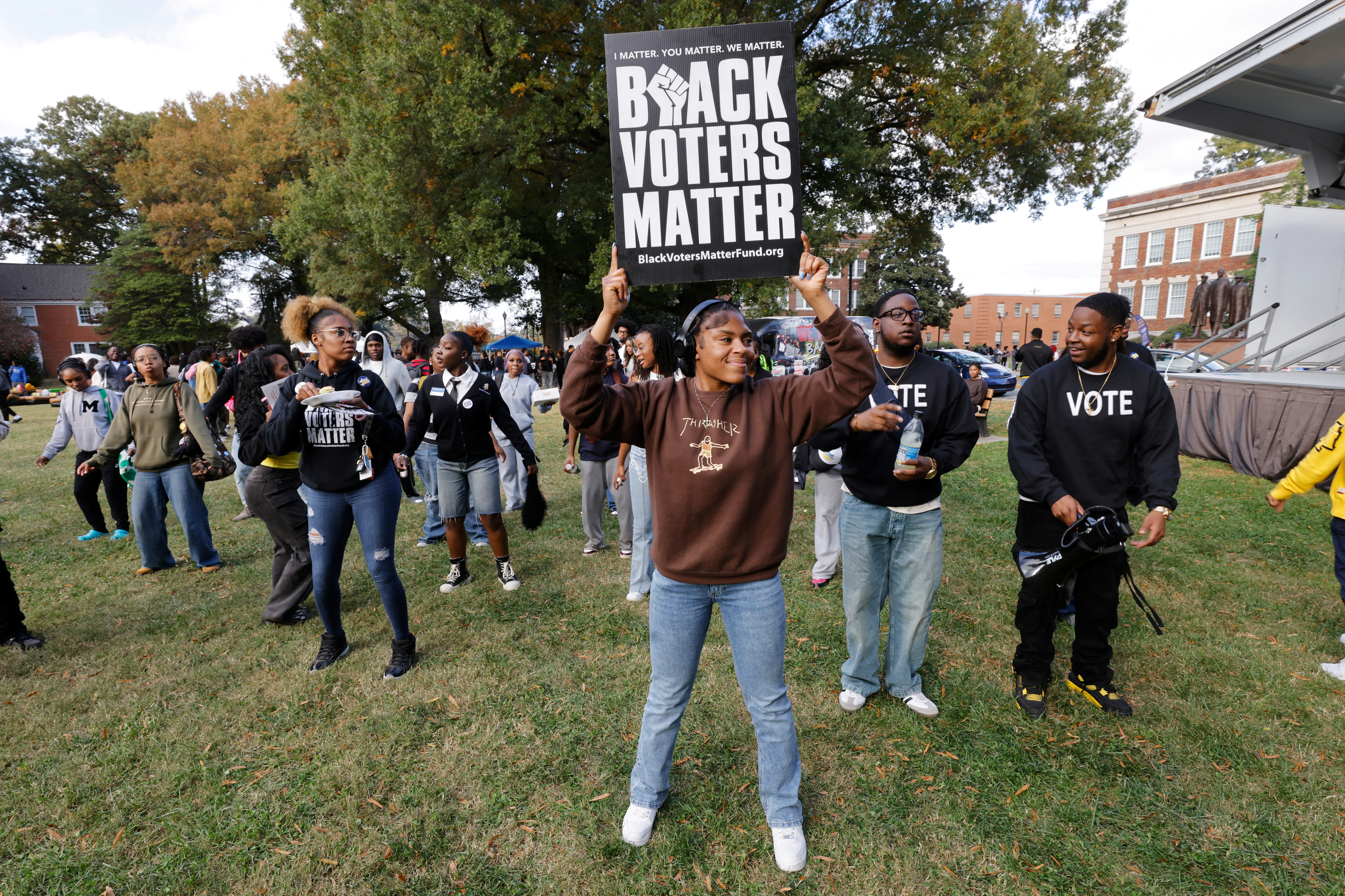 A university student holds up a sign on the campus lawn that reads, "Black voters matter."