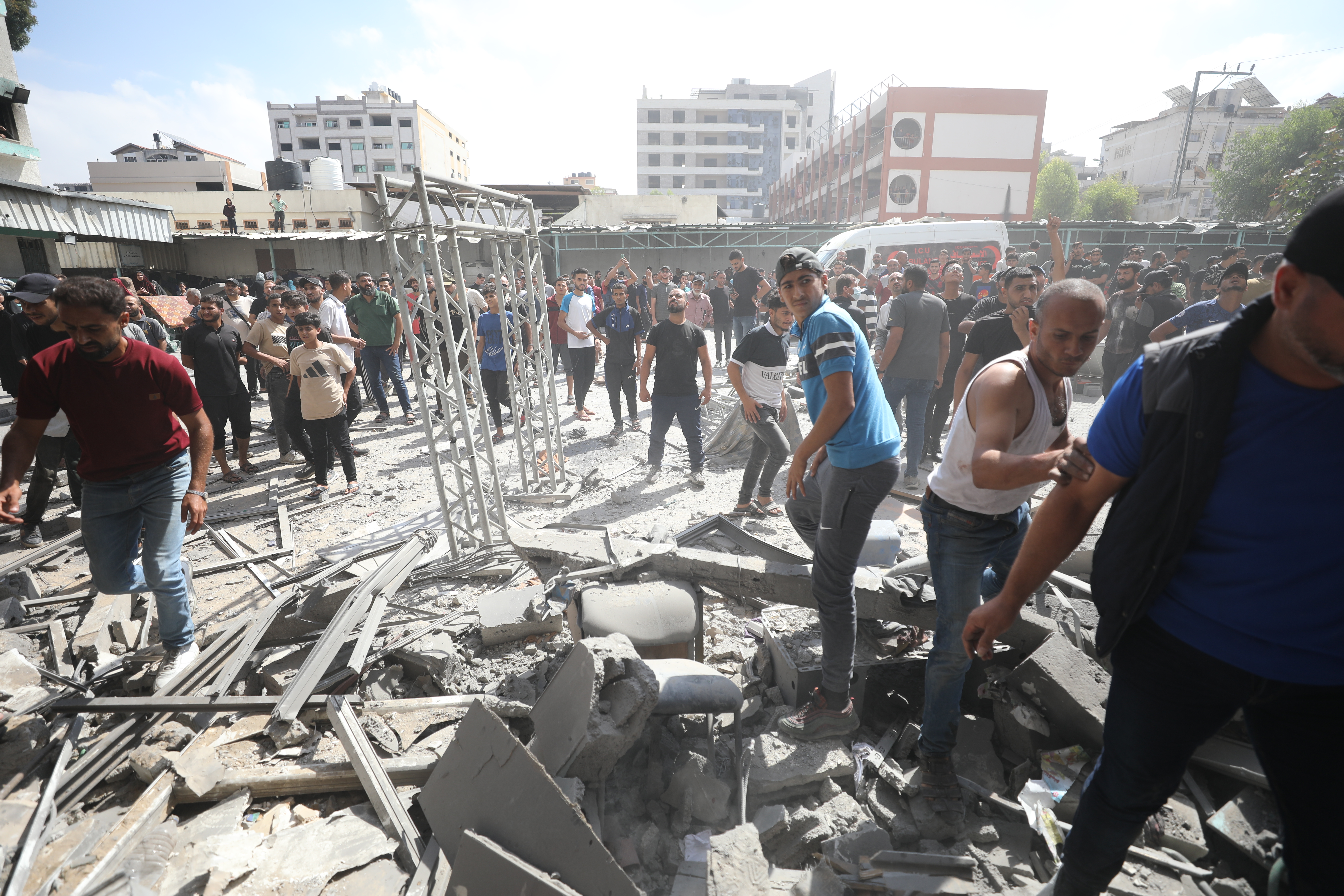 Palestinian residents and Civil Defense teams launch a search and rescue operation following the Israeli army attack on the al-Rimal Clinic on Al Wahda Street in Gaza City, Gaza on October 10