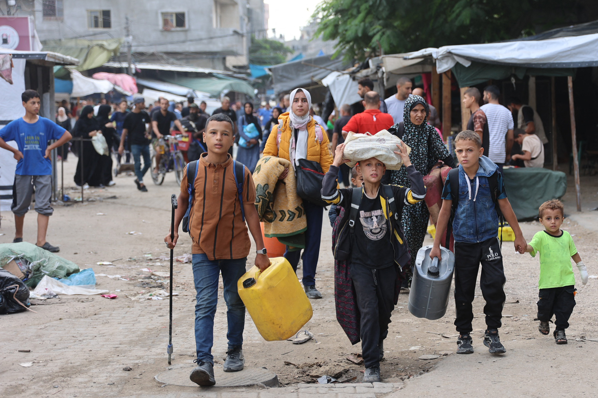 Palestinian families arrive in Gaza City after evacuating their homes in the Jabalia area on October 6,