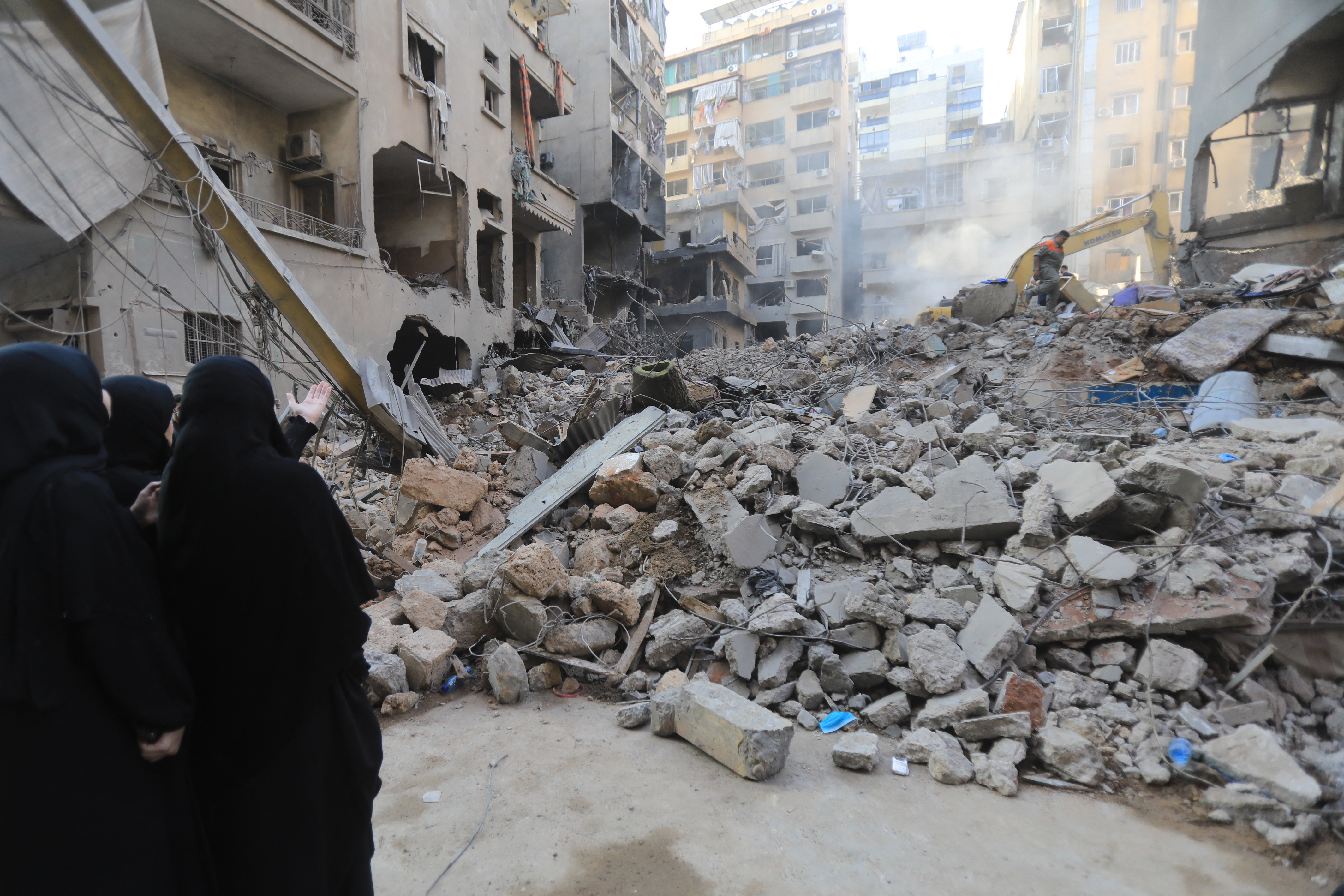 People walk past the rubble of a building at the site of an Israeli strike on the Basta neighbourhood in the Lebanese capital Beirut on October 11