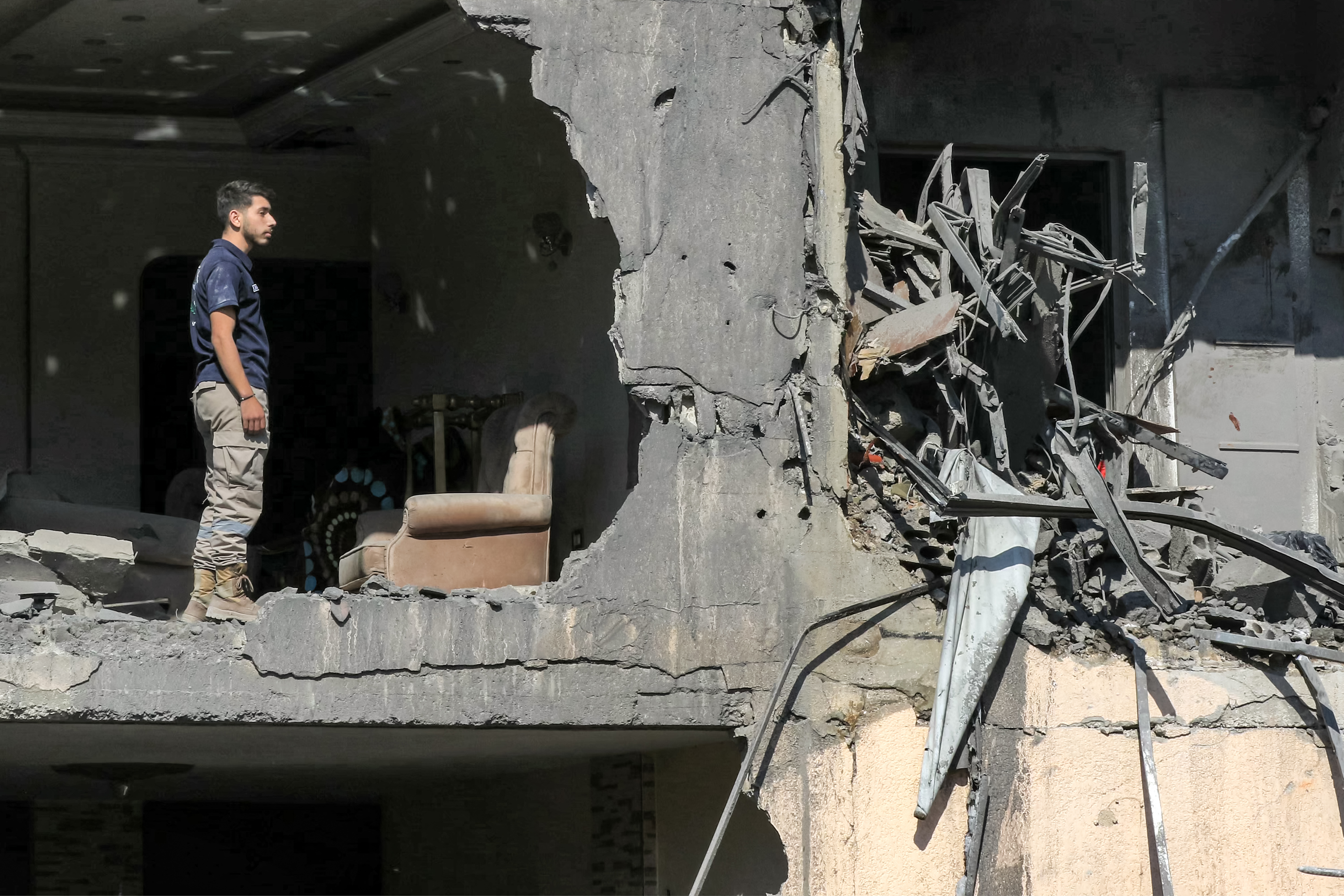 A man stands in a heavily-damaged building that was hit by an overnight Israeli air strike on town of Sarafand, between Sidon and Tyre in southern Lebanon, on October 30, 2024. - Israel expanded operations in Lebanon nearly a year after Hezbollah began exchanging fire in support of its ally, Hamas, following the Palestinian group's deadly attack on Israel on October 7, 2023. (Photo by Mahmoud ZAYYAT / AFP)