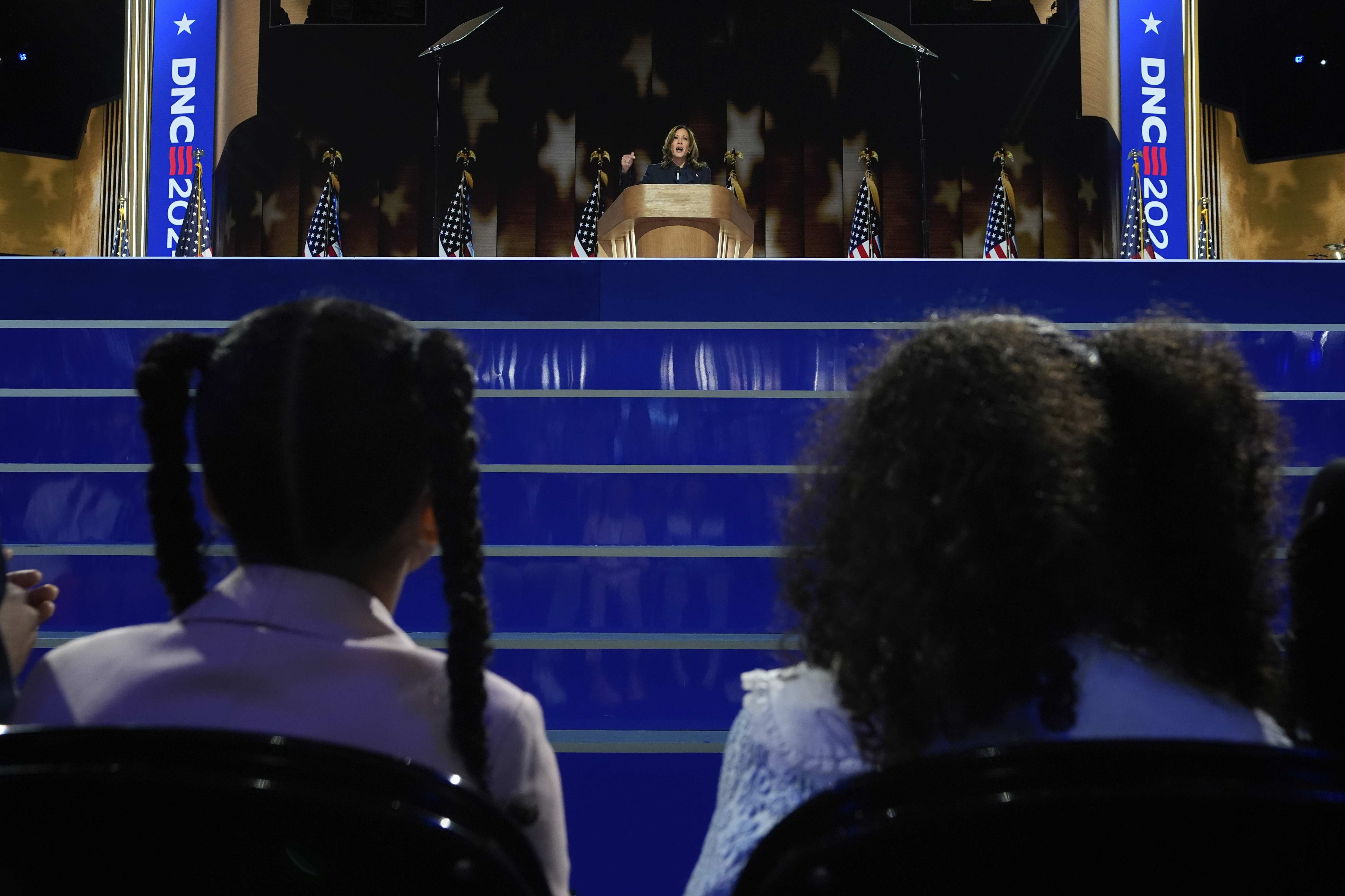 Democratic presidential nominee Vice President Kamala Harris speaks as her grand-nieces Amara Ajagu, left, and Leela Ajagu watch.