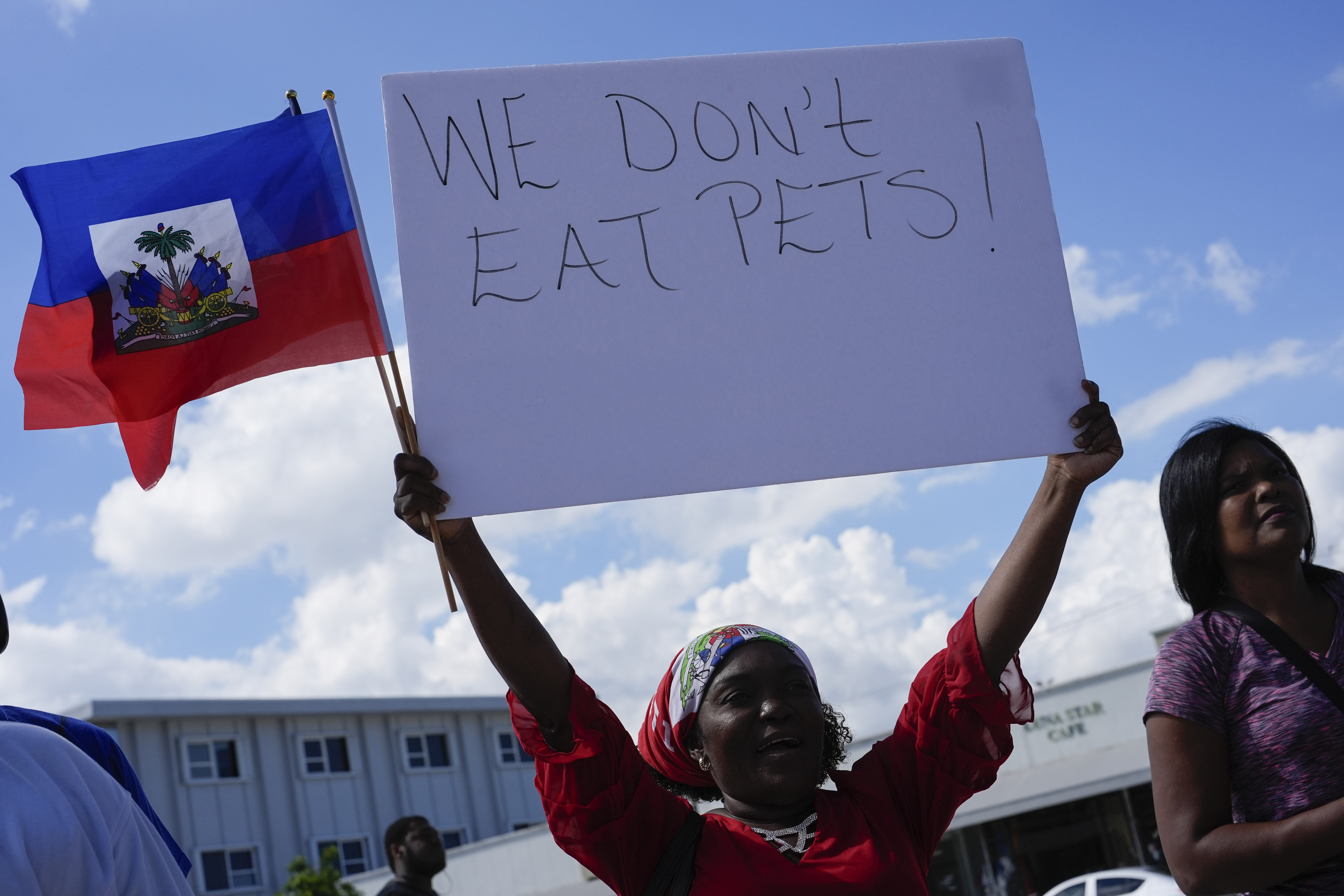 Wilda Brooks of West Palm Beach, Fla., holds up a sign reading "We don't eat pets," during a rally by members of South Florida's Haitian-American community to condemn hate speech and misinformation about Haitian immigrants, Sunday, Sept. 22, 2024, in North Miami, Fla. (AP Photo/Rebecca Blackwell)