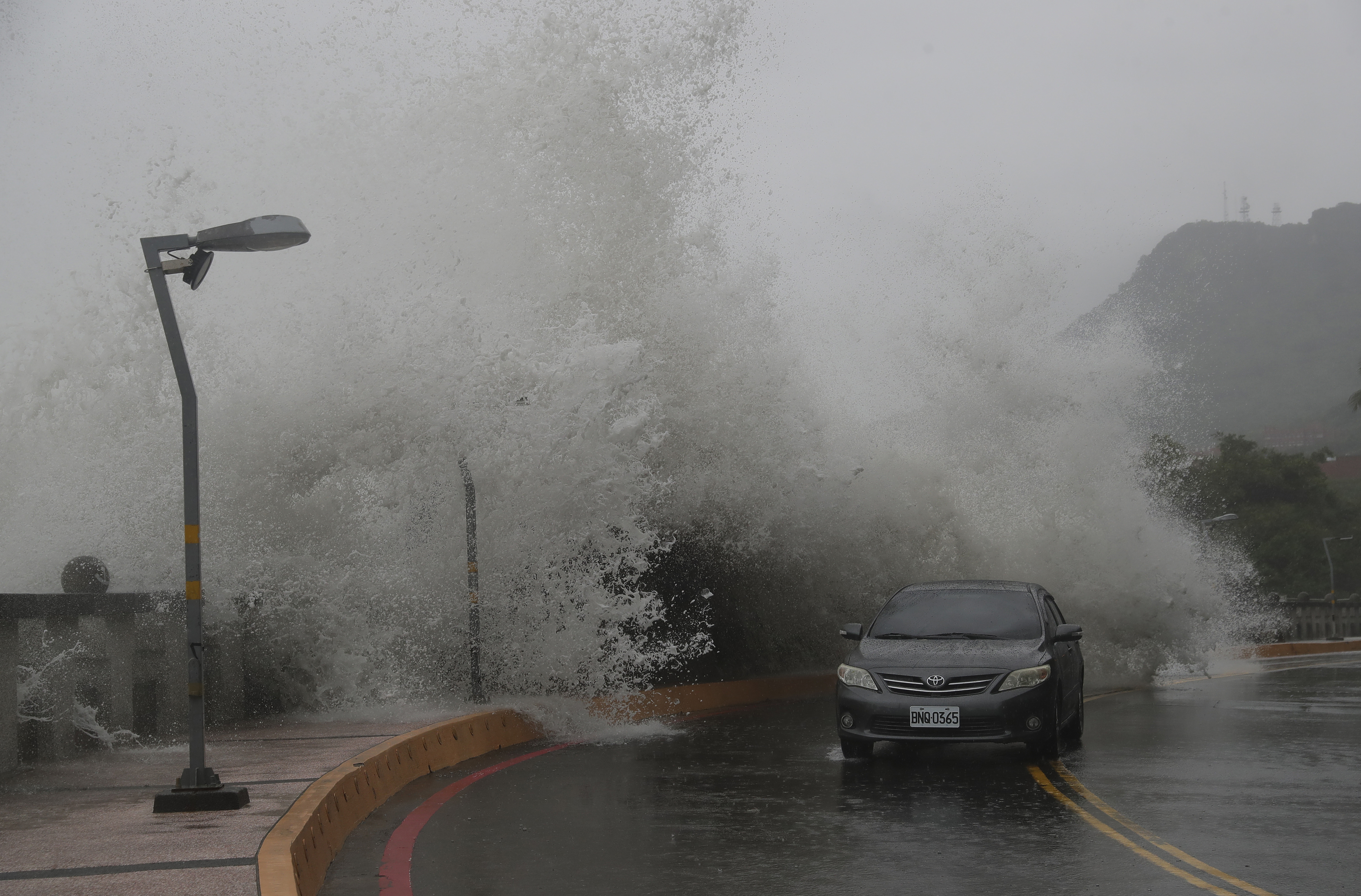 A car moves along the shore in Kaohsiung, Southern Taiwan, Wednesday, Oct. 2, 2024, as Typhoon Krathon is expected to hit the area