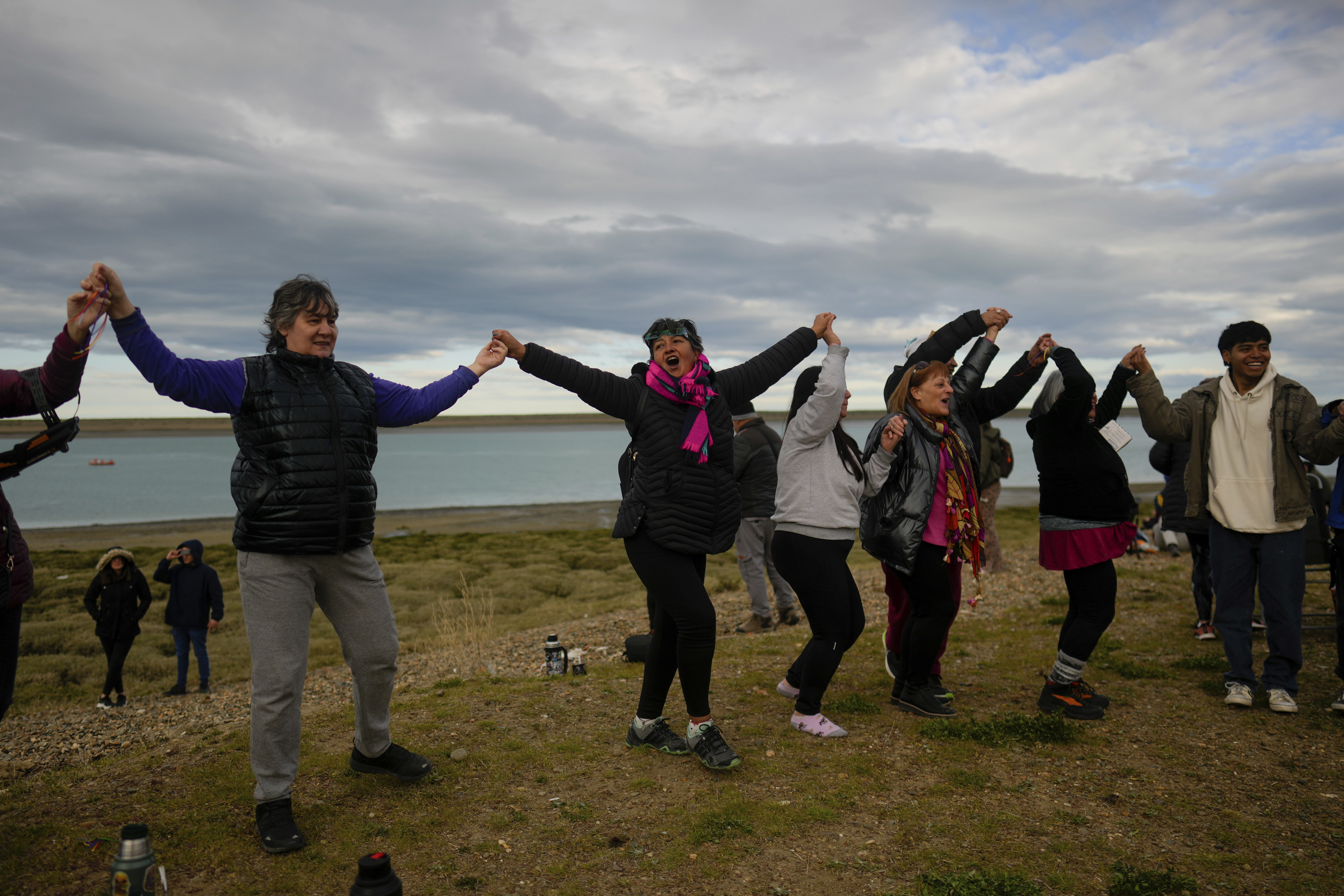 People dance and hold hands in a line as the eclipse unfolds.