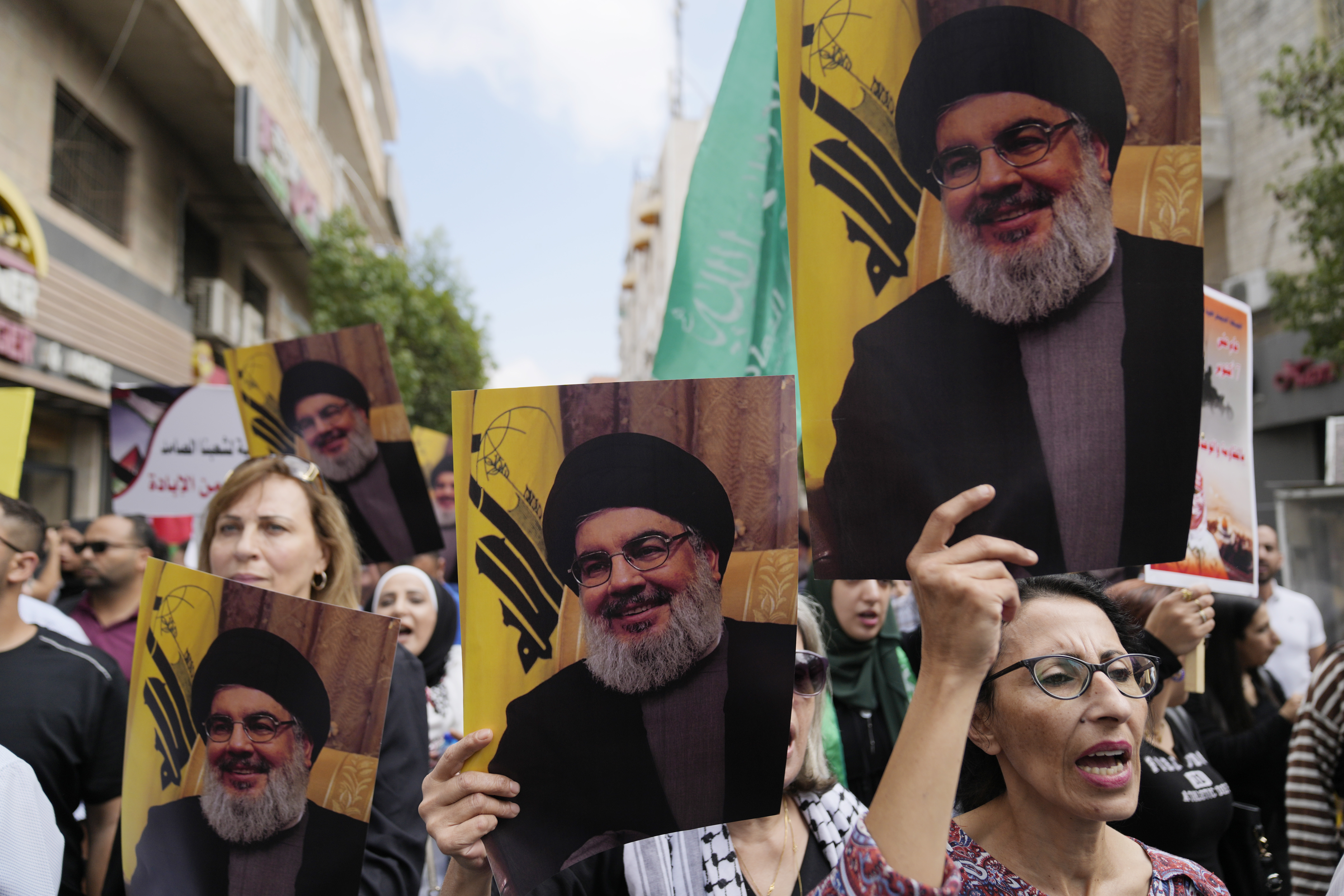 Palestinian activists hold posters with pictures of late Hezbollah leader Hassan Nasrallah during a protest marking the one year anniversary of the Israel Hamas war, in the West Bank city of Ramallah, Monday, Oct. 7