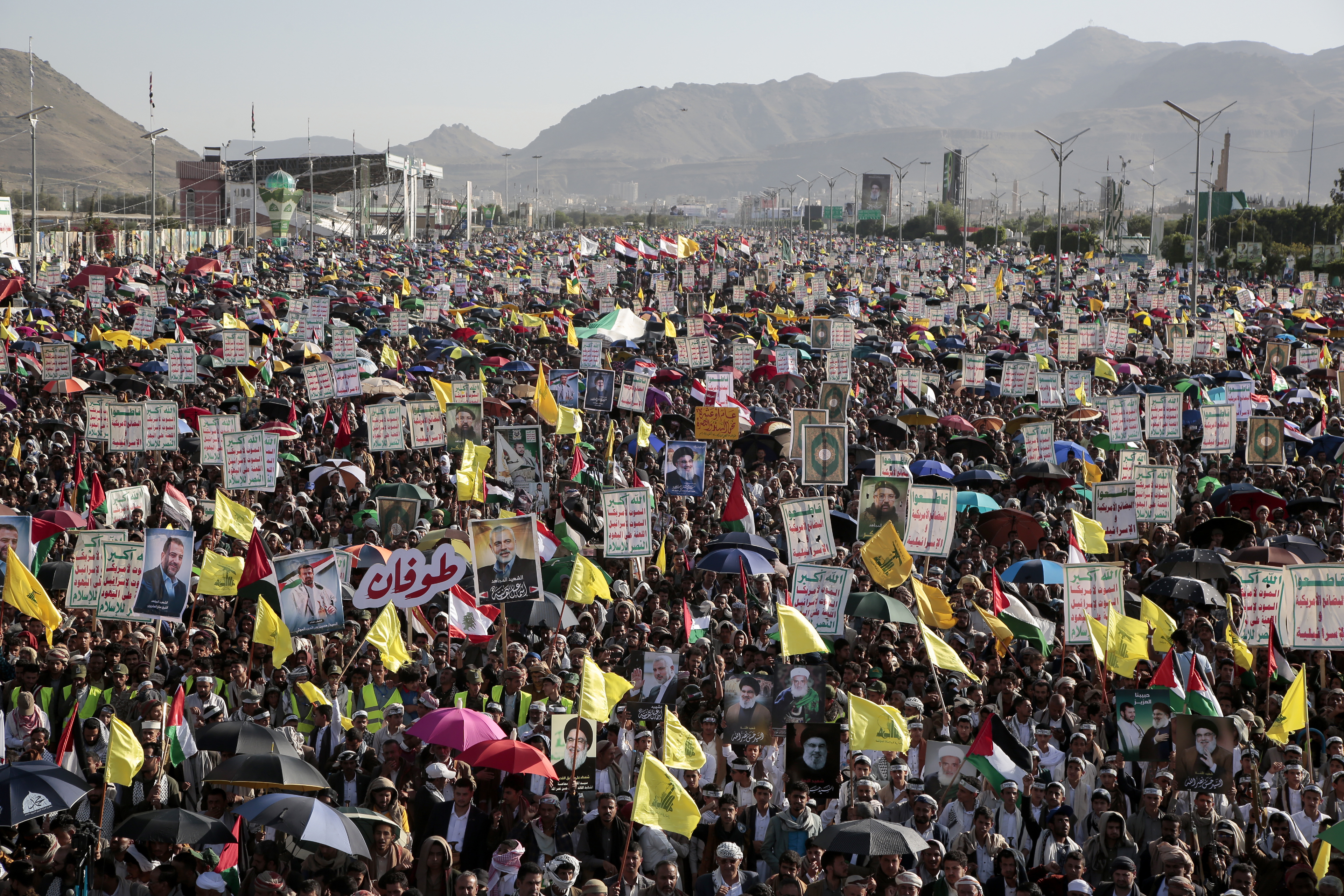 Thousands of Houthi supporters raise Hezbollah flags and posters of late leader Hassan Nasrallah during a rally to commemorate the one-year anniversary of the war in the Gaza Strip, in Sanaa, Yemen, Monday, Oct. 7