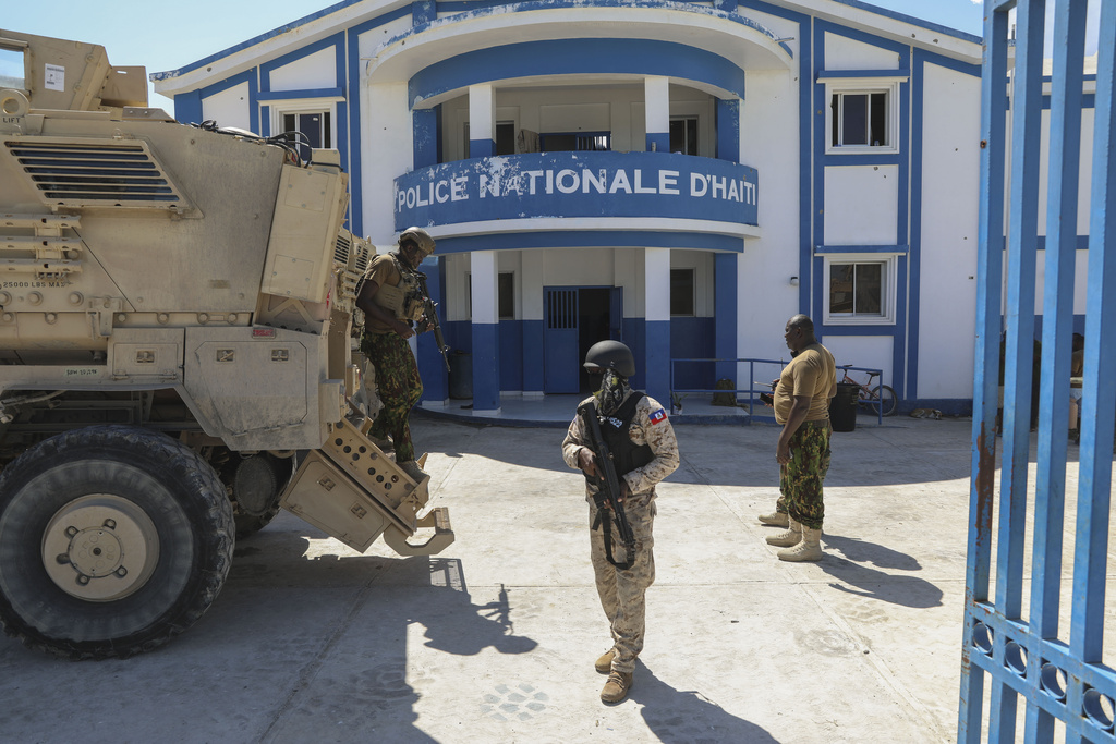 Armed police stand near an armoured vehicle