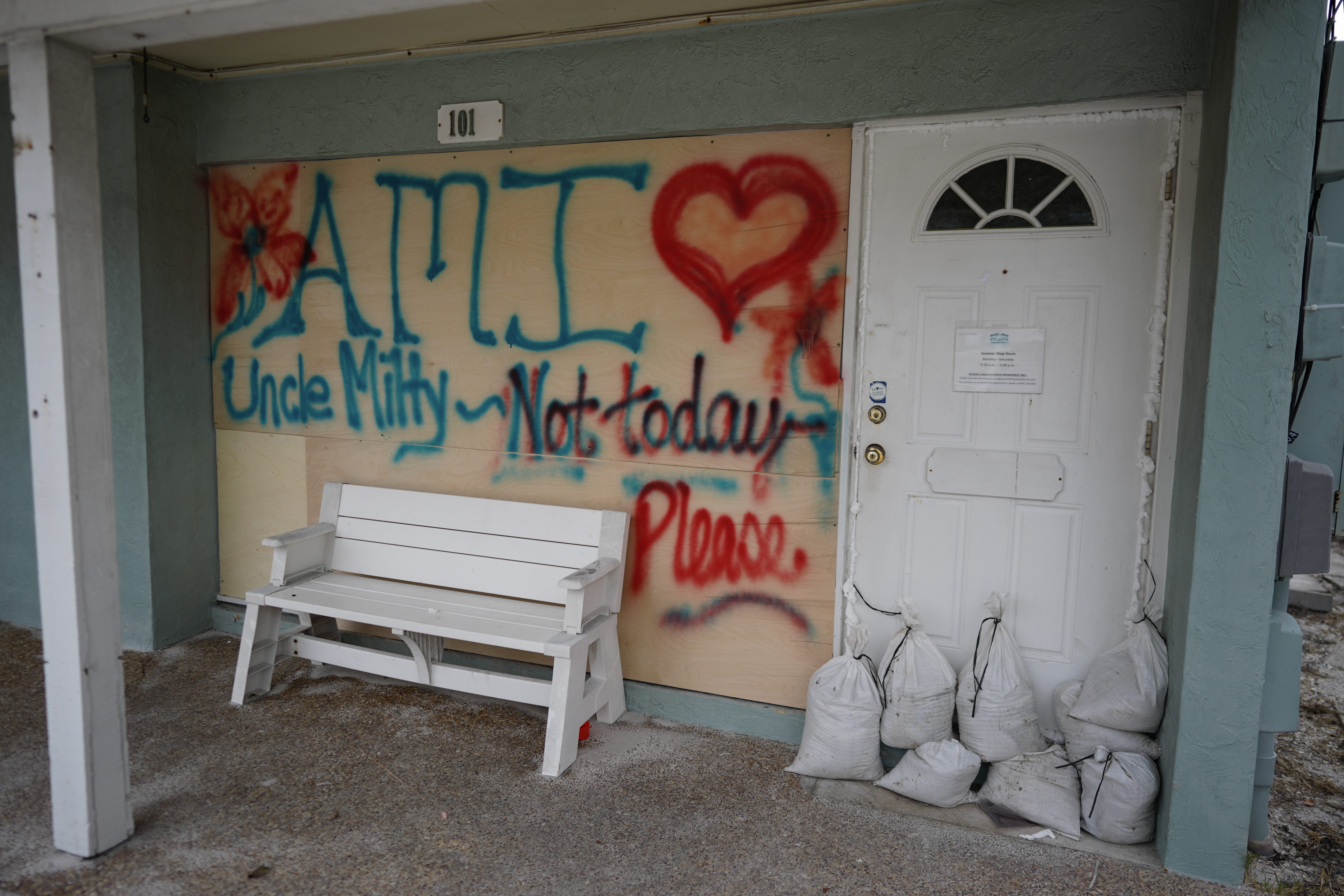Boards on the window of a store display a message ahead of the arrival of Hurricane Milton, in Bradenton Beach on Anna Maria Island, Fla., Tuesday, Oct. 8