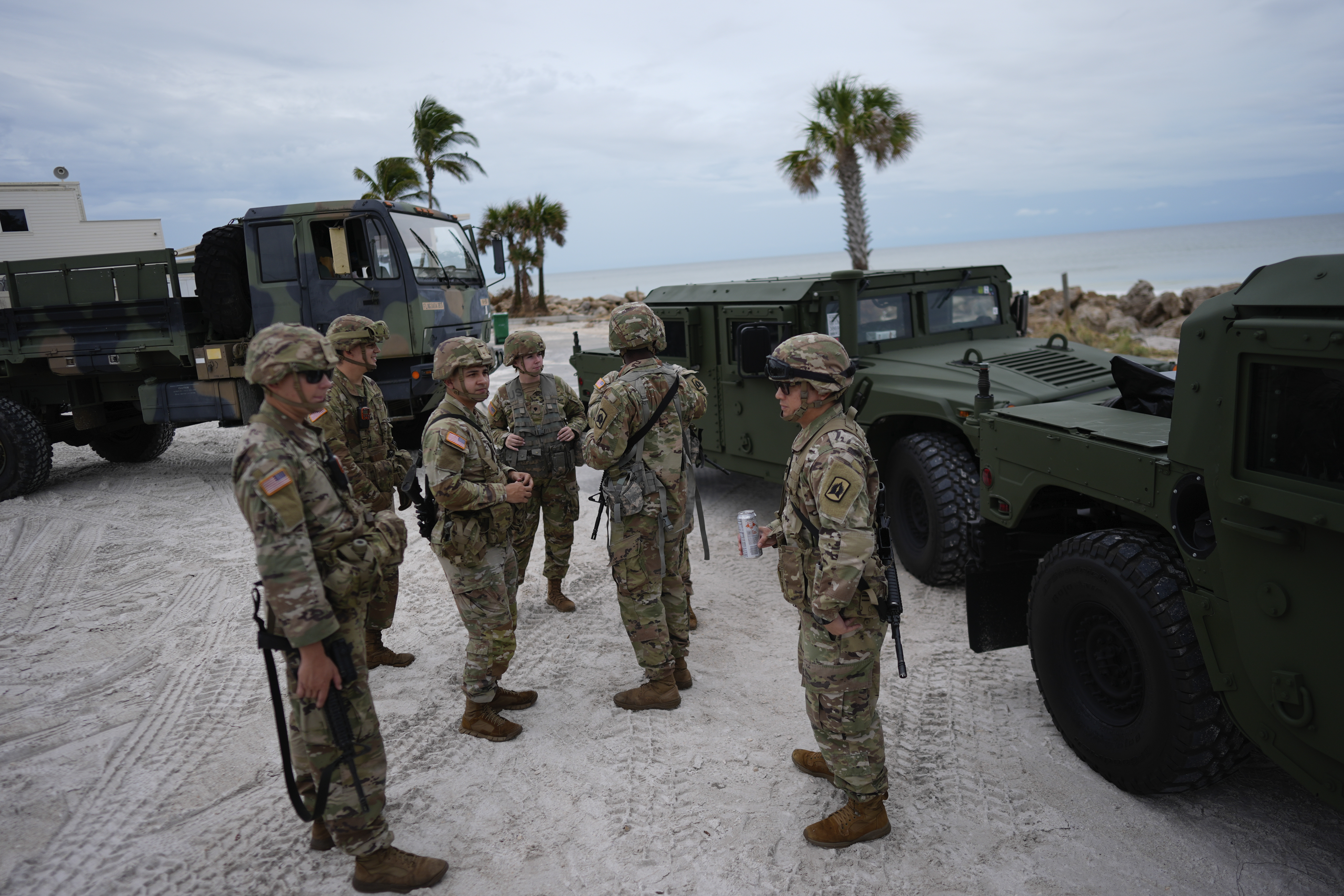 Members of the Florida Army National Guard stage on a beach as they prepare for the arrival of Hurricane Milton, in Bradenton Beach on Anna Maria Island, Fla., Tuesday, Oct. 8