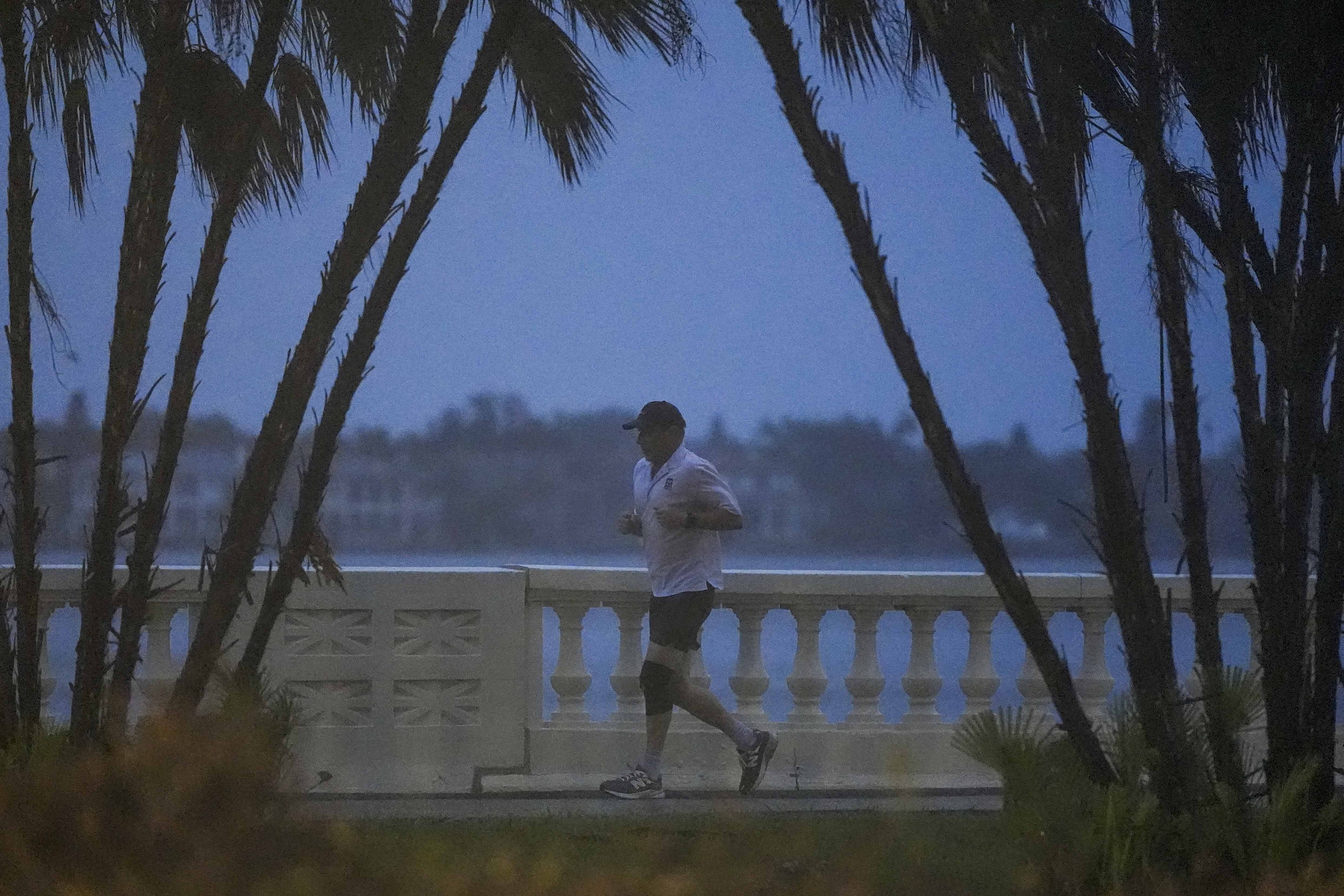 A jogger runs along the bay in heavy rain ahead of Hurricane Milton, Wednesday, Oct. 9, 2024, in Tampa, Fla
